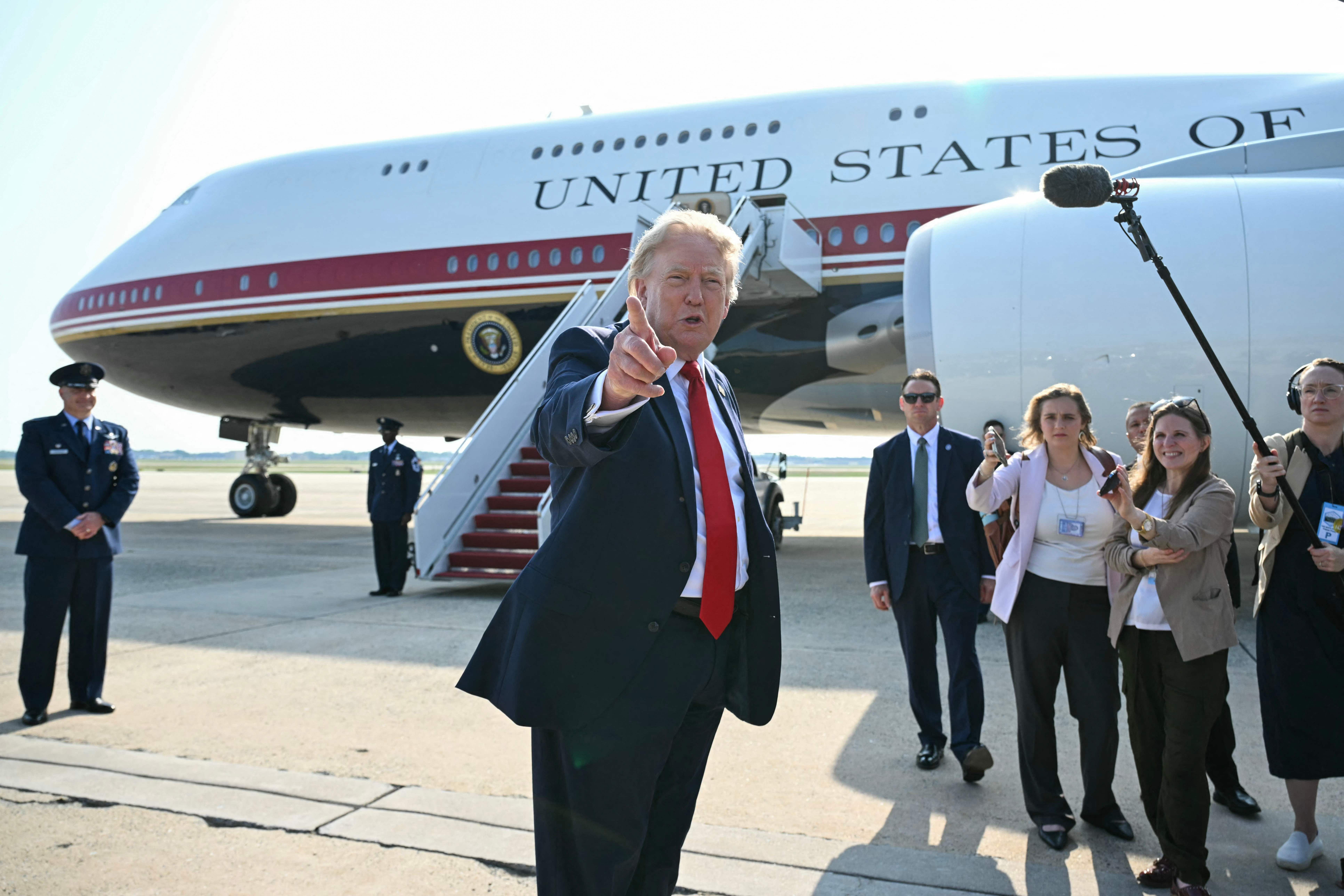 US-Präsident spricht zur Presse vor Air Force One auf dem Rollfeld mit Crew und Journalisten.