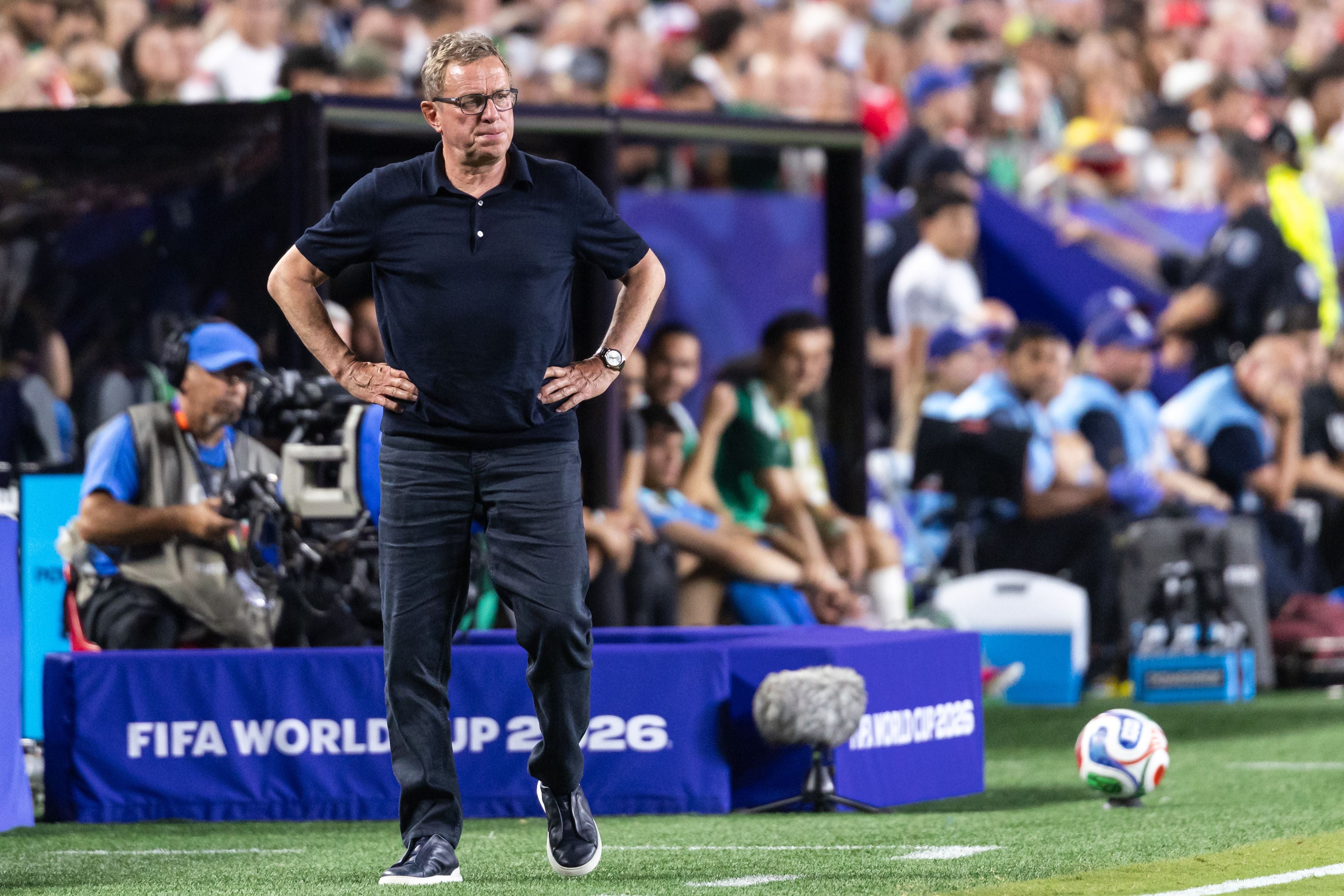 Ein Fußballtrainer steht nachdenklich am Spielfeldrand beim FIFA WM-Spiel 2026.