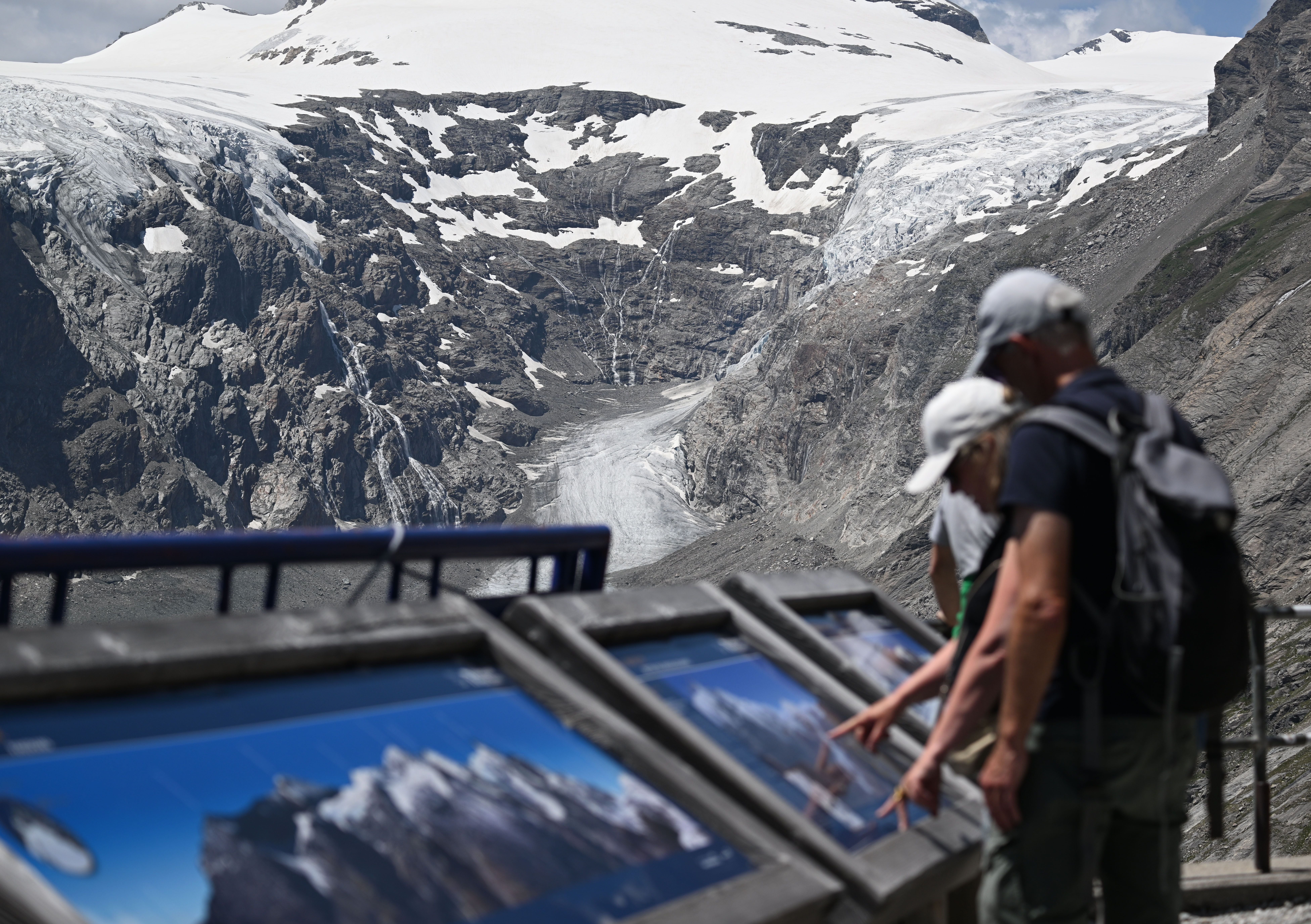 Besucher betrachten Informationstafeln vor dem Pasterzengletscher bei der Kaiser-Franz-Josefs-Höhe.