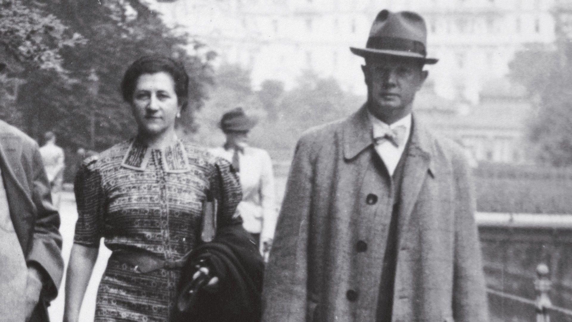 Schwarzweißfoto eines Mannes und einer Frau, die gemeinsam draußen spazieren gehen.