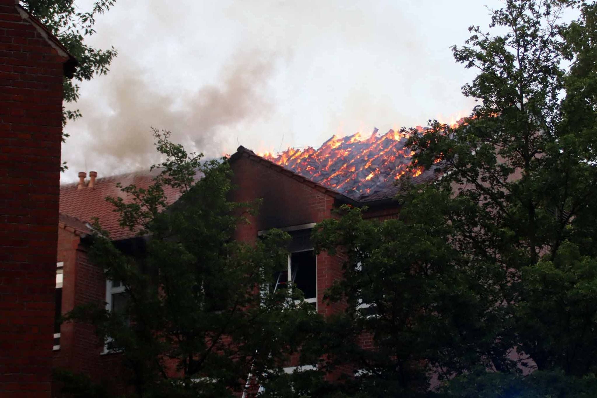 Ein Krankenhausdach in Ludwigslust steht in Flammen, dichter Rauch steigt auf.