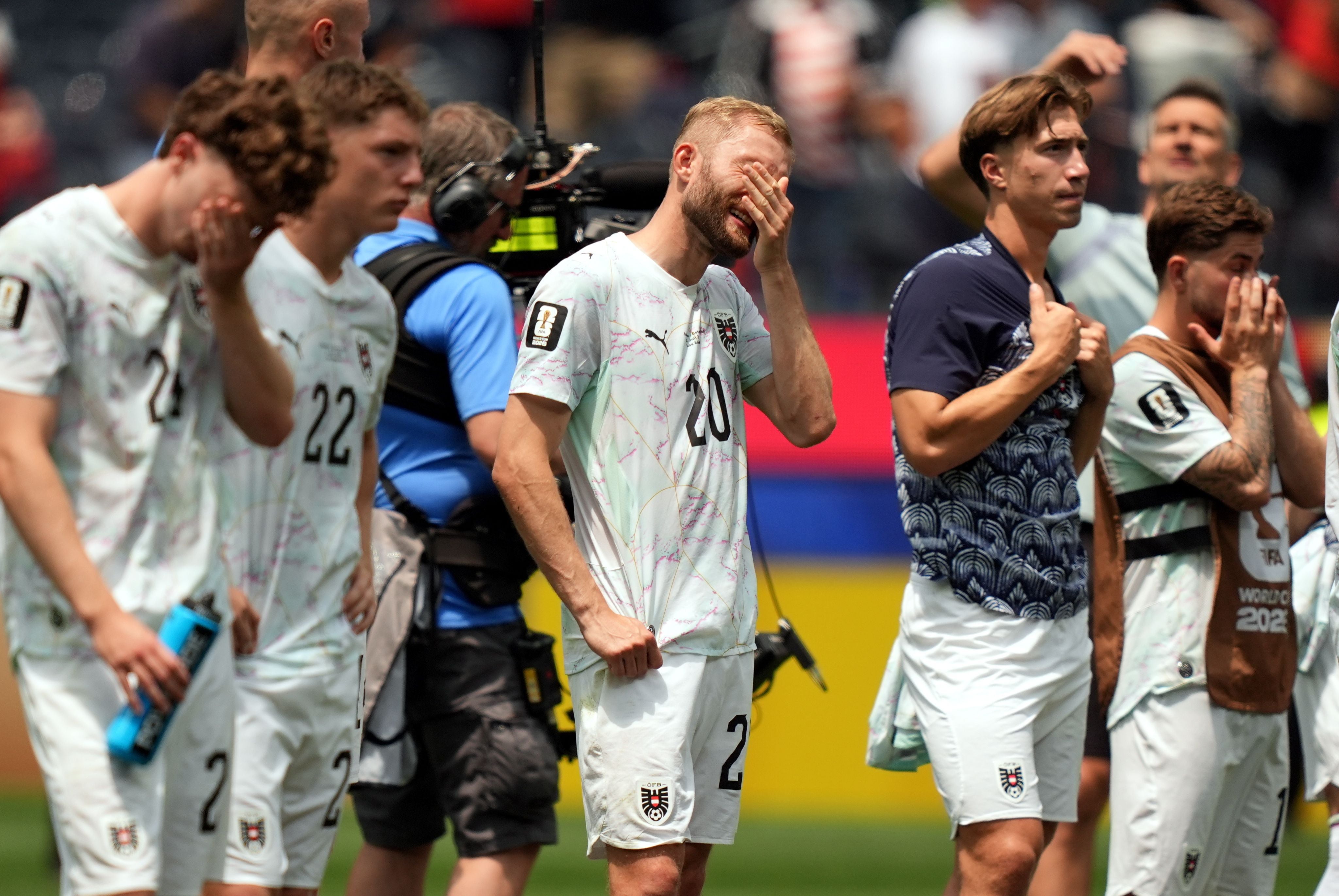 Österreichische Fußballspieler stehen enttäuscht und fassen sich nach einer Niederlage ins Gesicht.