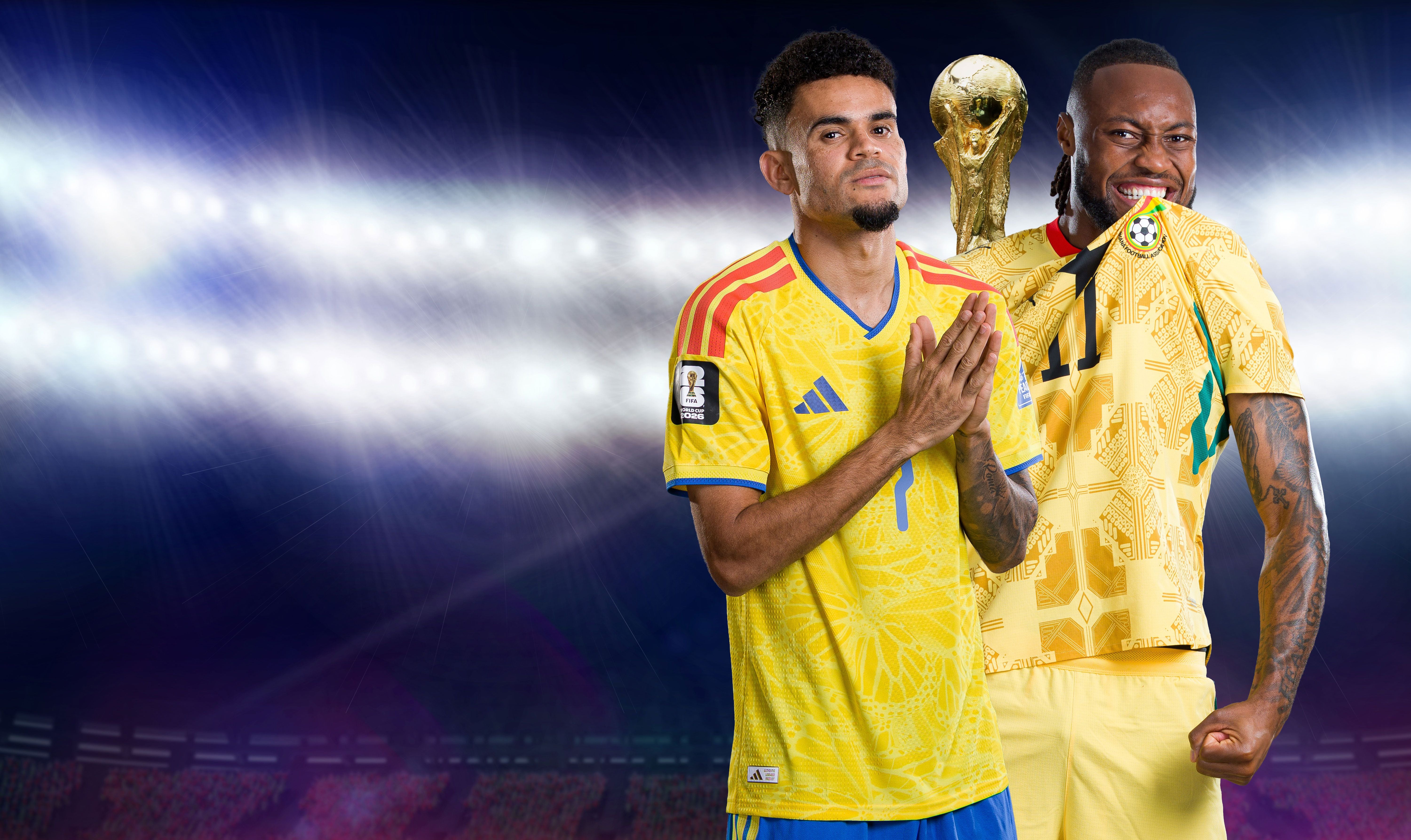 Zwei Fußballspieler aus Ghana und Kolumbien posieren im Stadion mit der WM-Trophäe im Hintergrund.