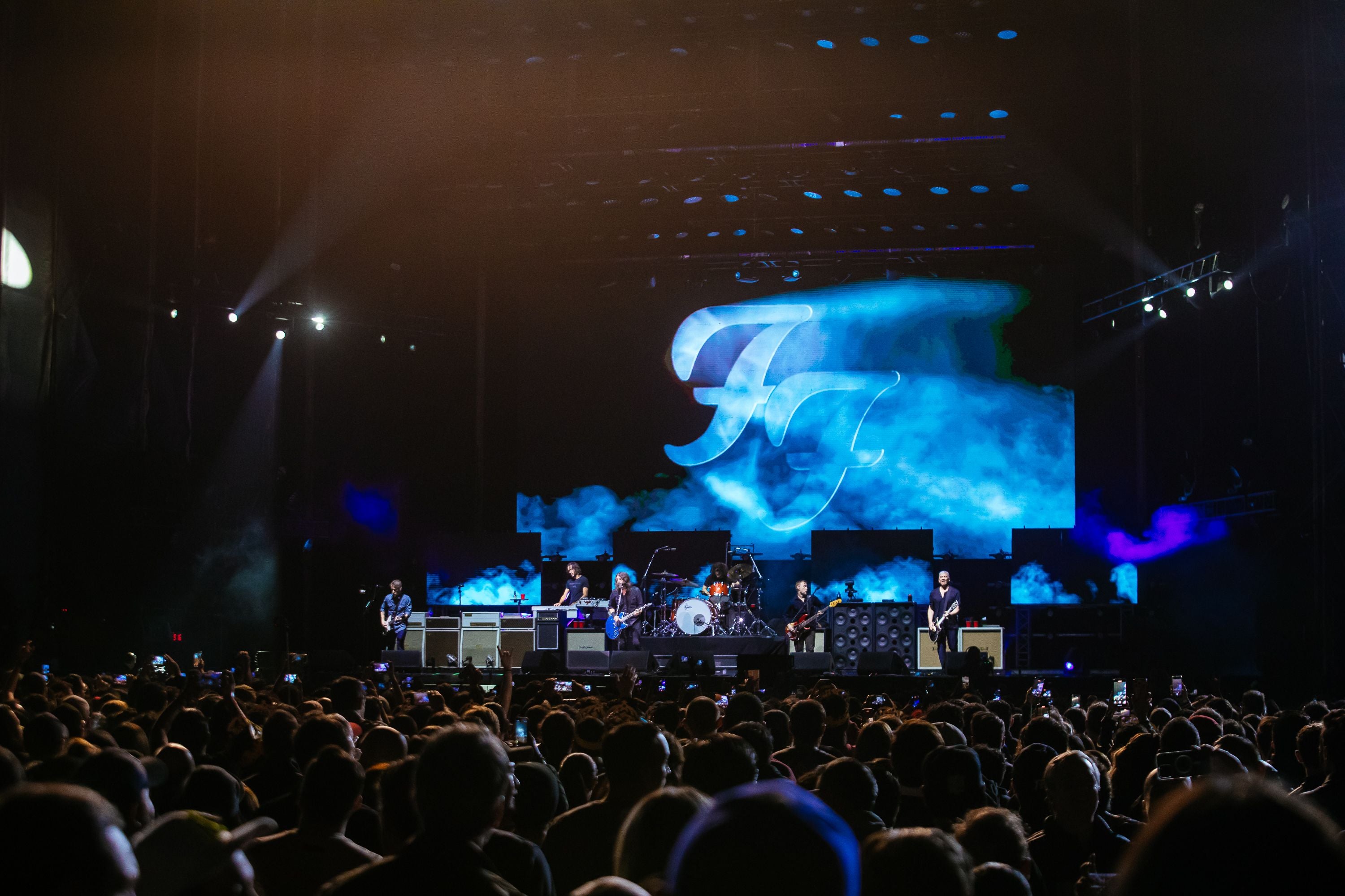 Die Foo Fighters spielen live auf einer beleuchteten Bühne vor großem Publikum.