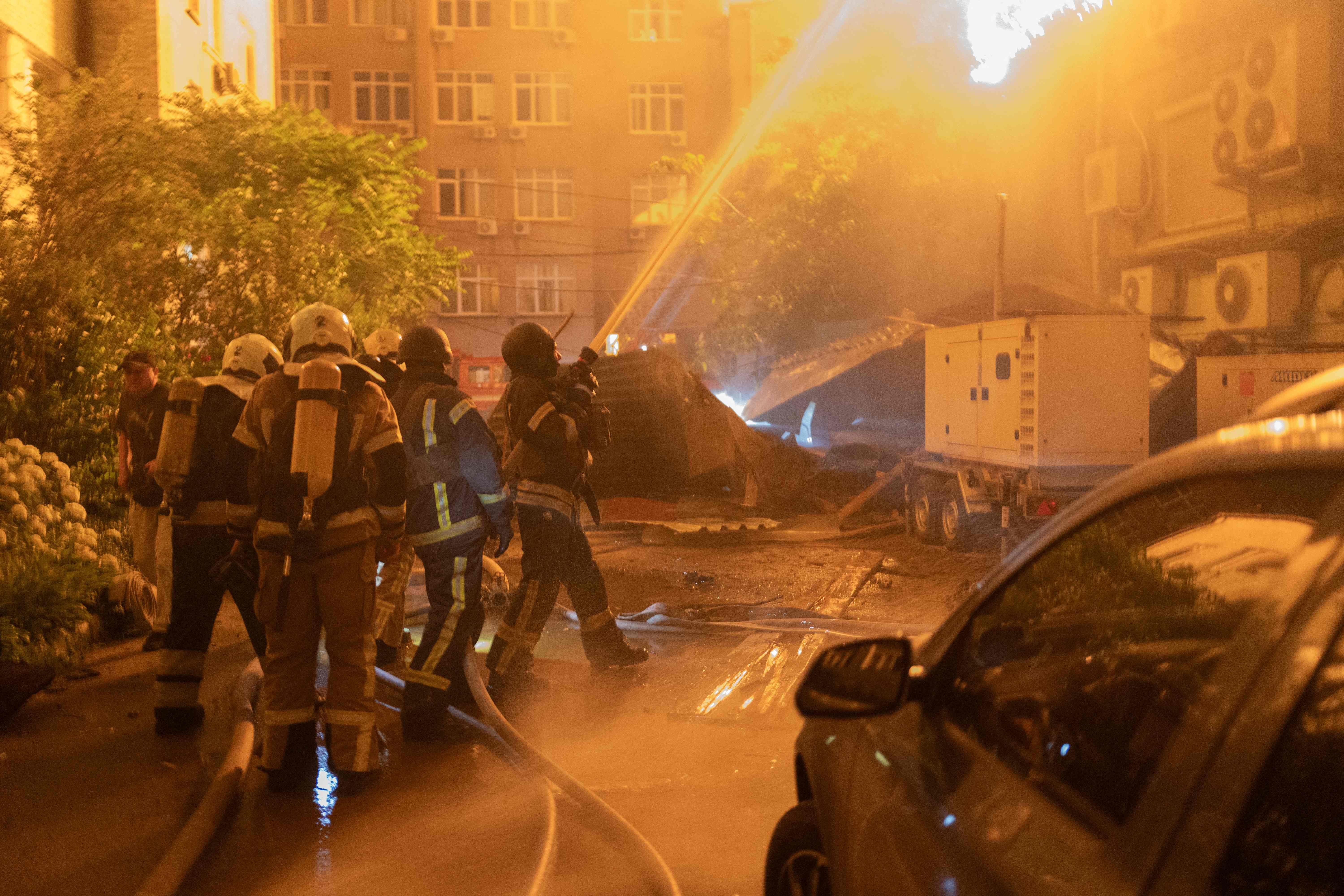 Feuerwehrleute löschen in der Nacht einen Brand nach einem Drohnenangriff in einem Wohngebiet.