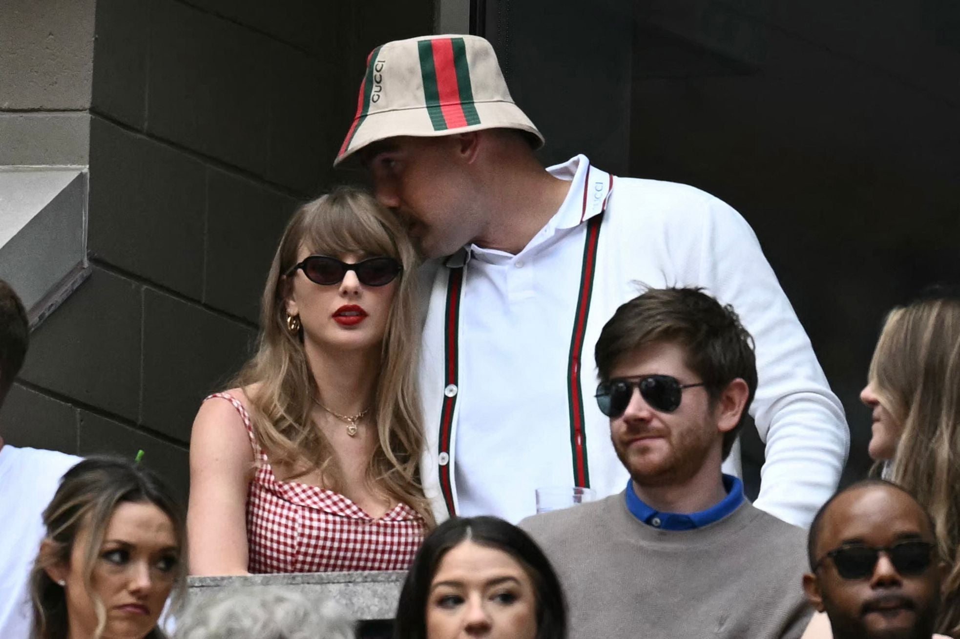 Taylor Swift und Travis Kelce stehen zusammen in einer Menschenmenge bei einem Sportevent.