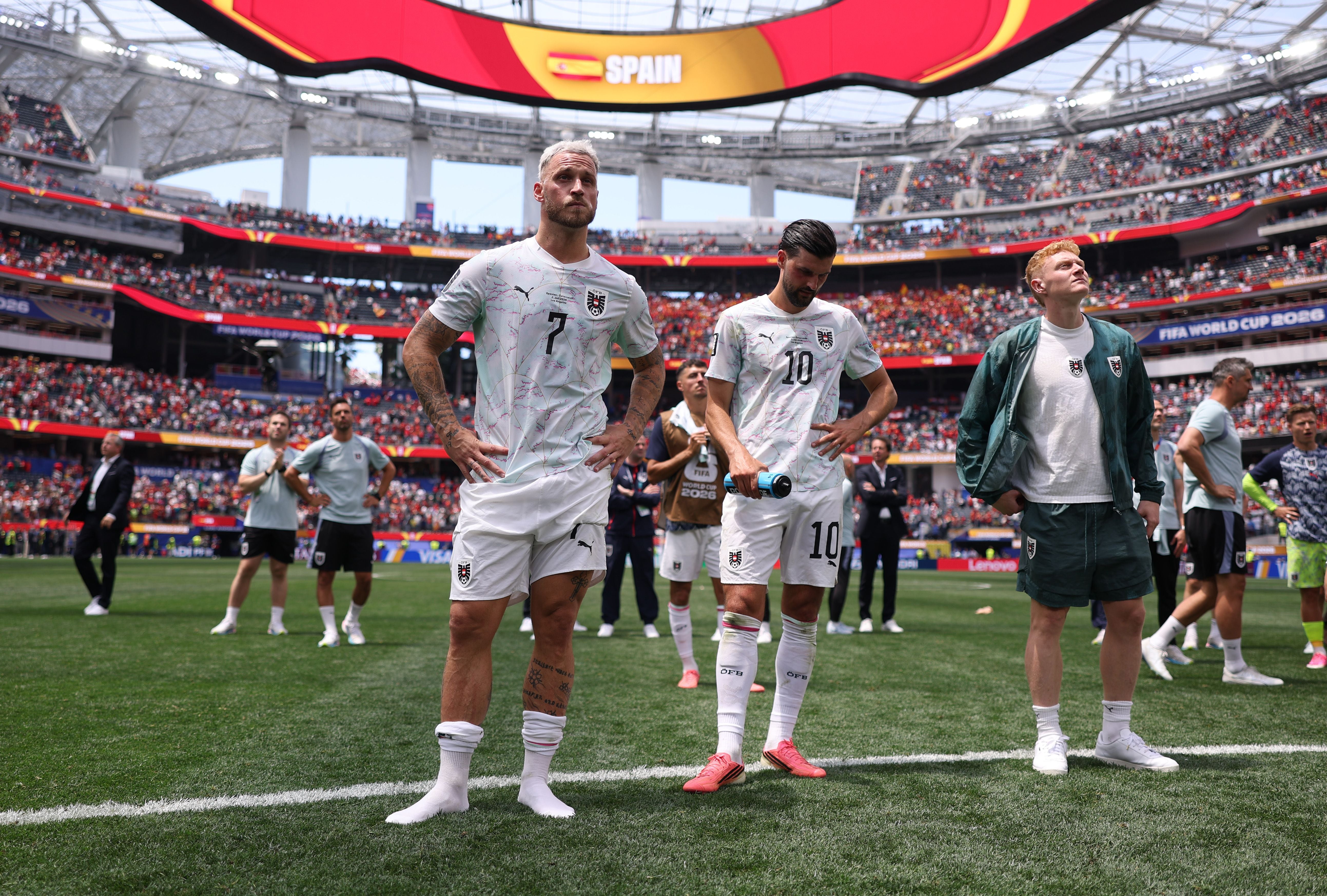 Österreichische Fußballspieler wirken enttäuscht nach einer Niederlage im Stadion.