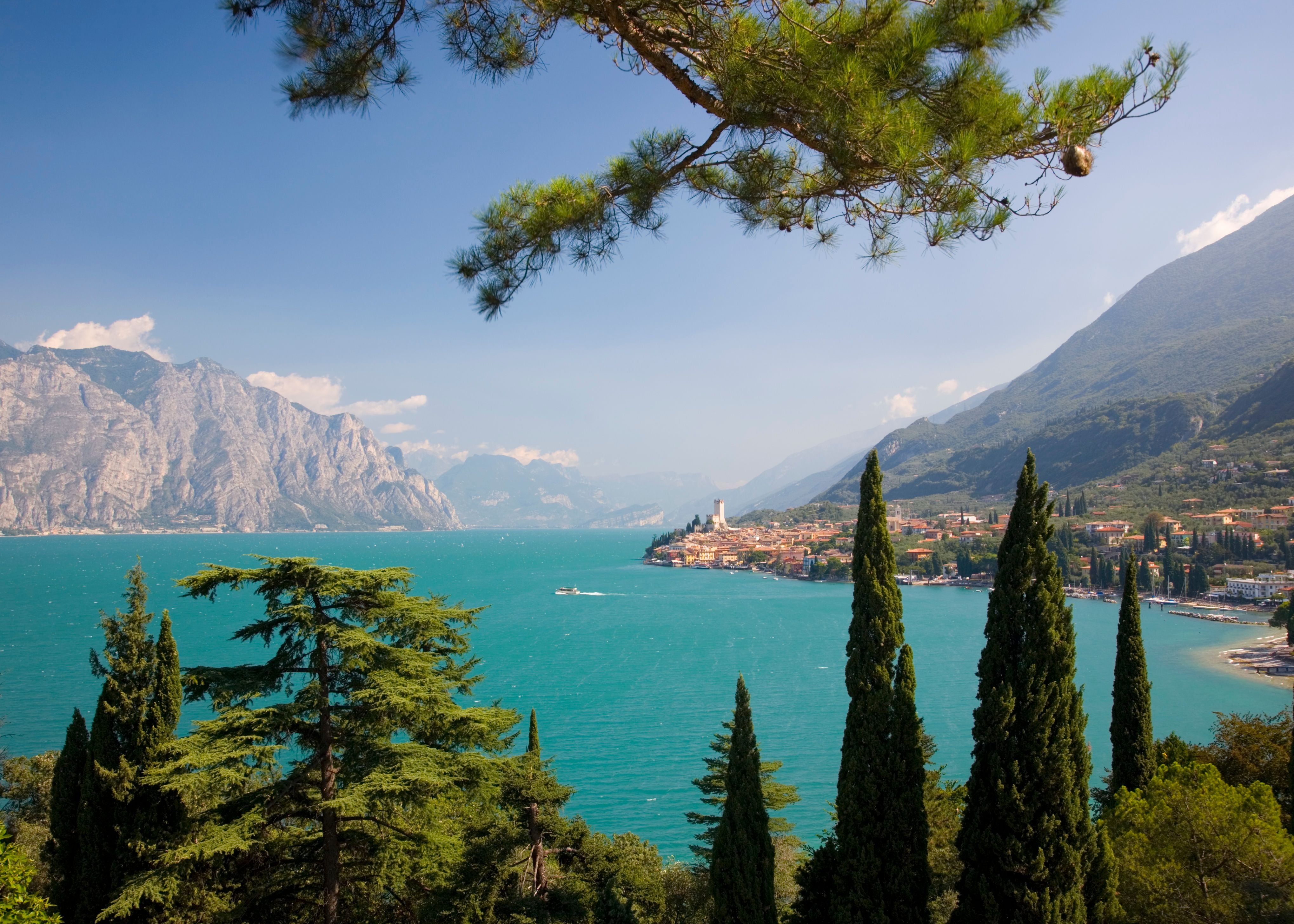 Blick auf Malcesine am Gardasee mit Bergen und türkisblauem Wasser im Hintergrund.