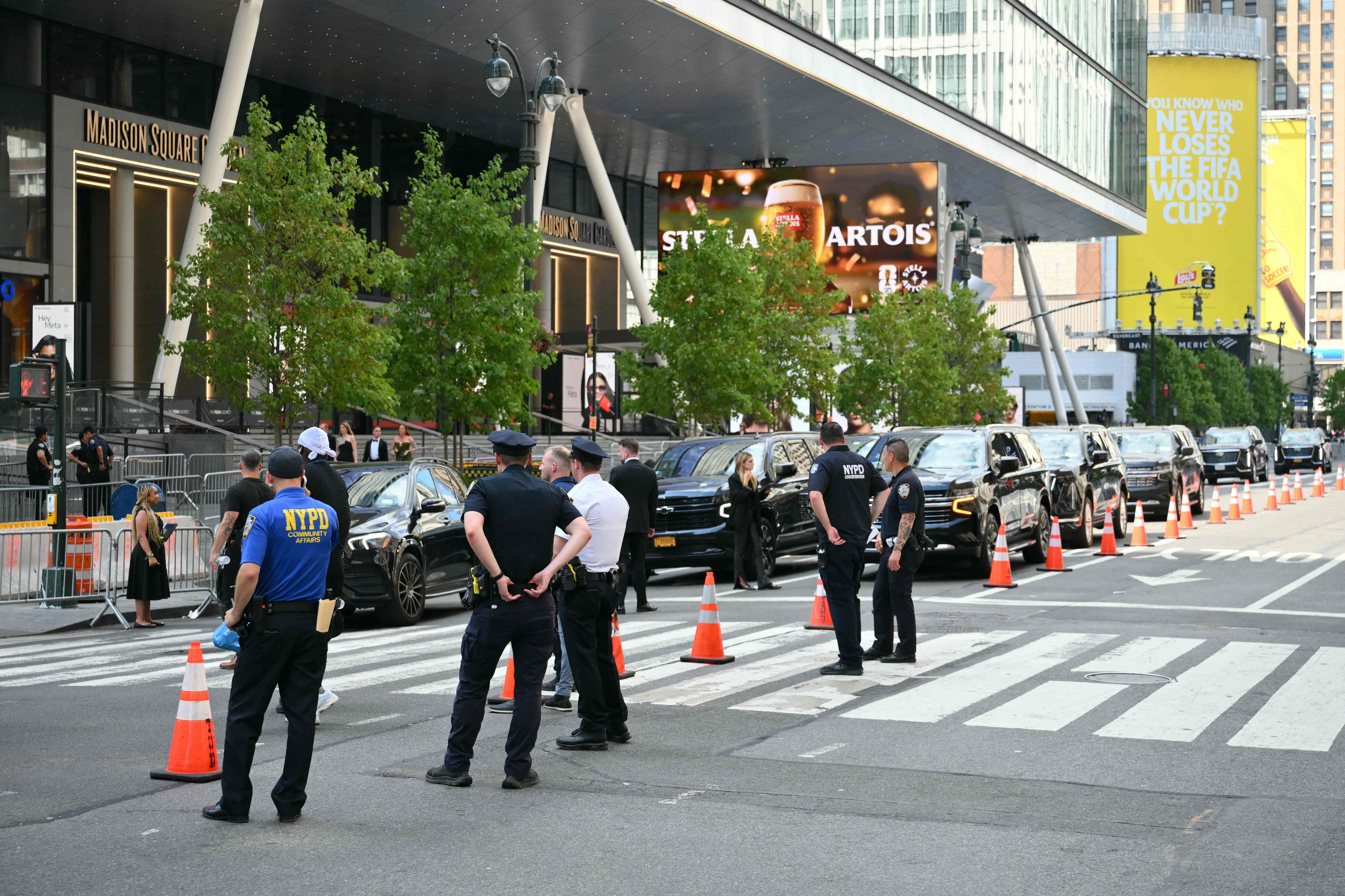 Polizisten sichern den Bereich vor dem Madison Square Garden, mehrere schwarze Autos stehen in Reihe.
