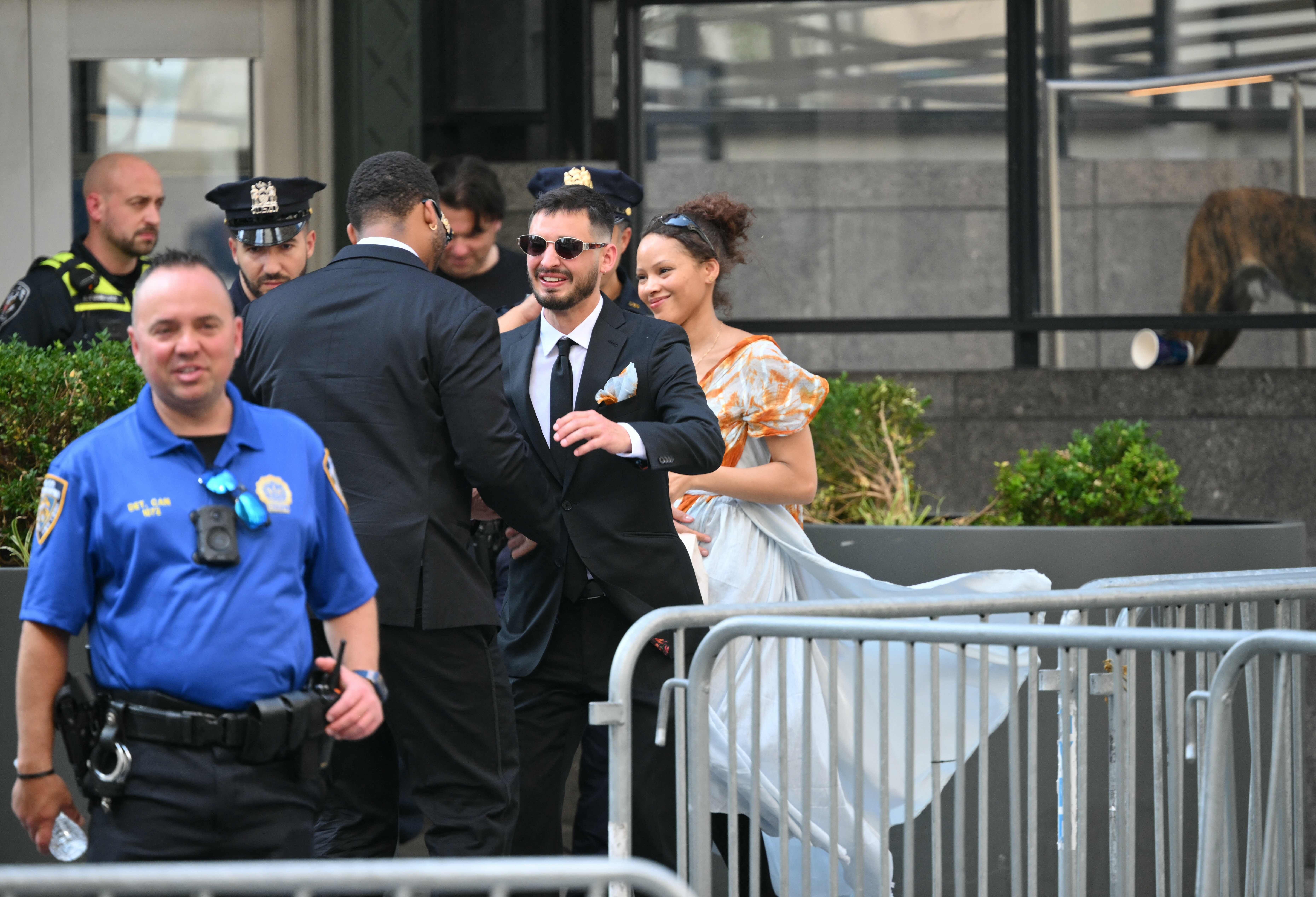 Menschen in eleganter Kleidung und Polizisten vor einem abgesperrten Bereich in New York City.