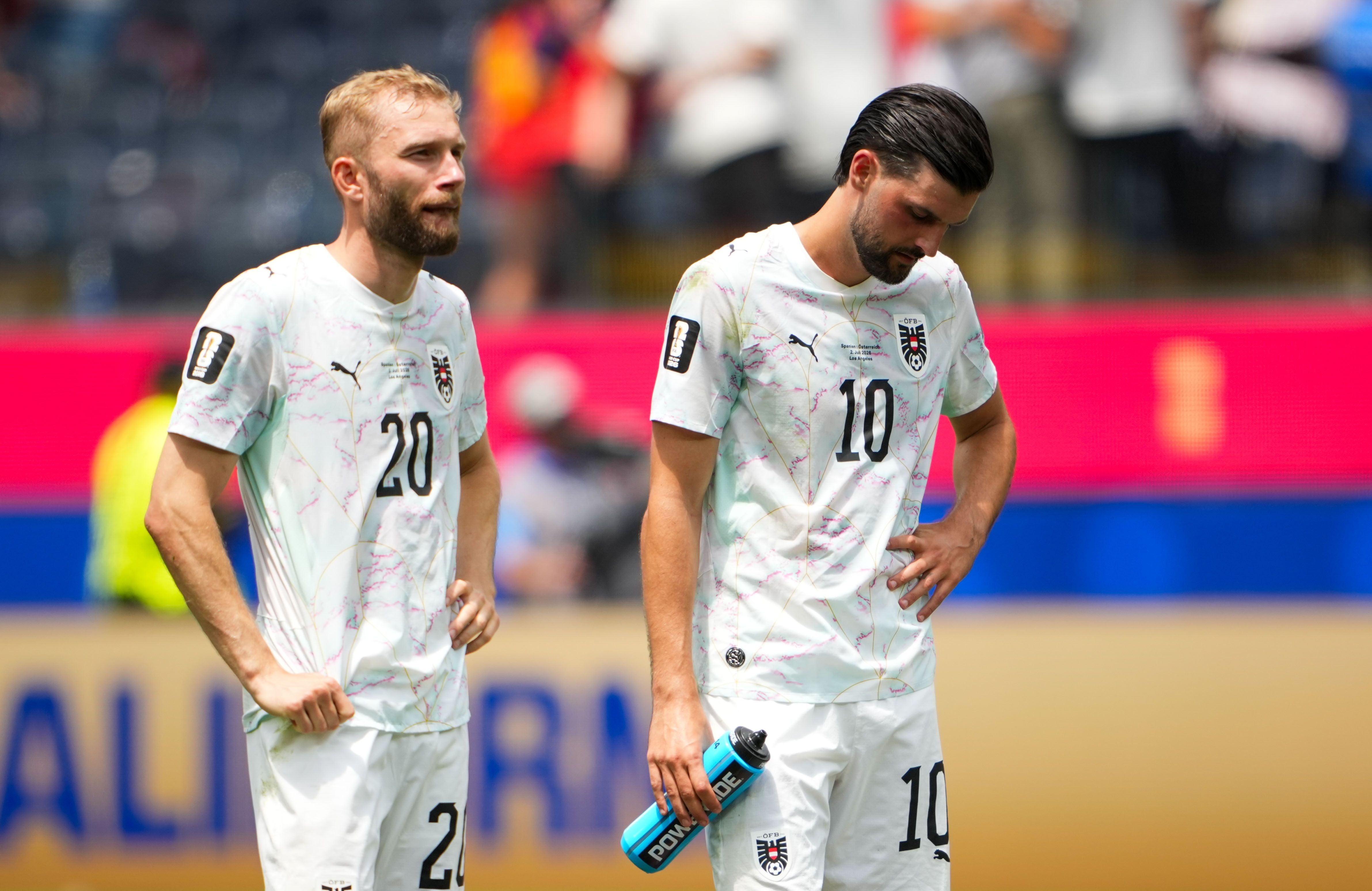 Zwei österreichische Fußballspieler wirken enttäuscht nach einem WM-Spiel in Los Angeles.