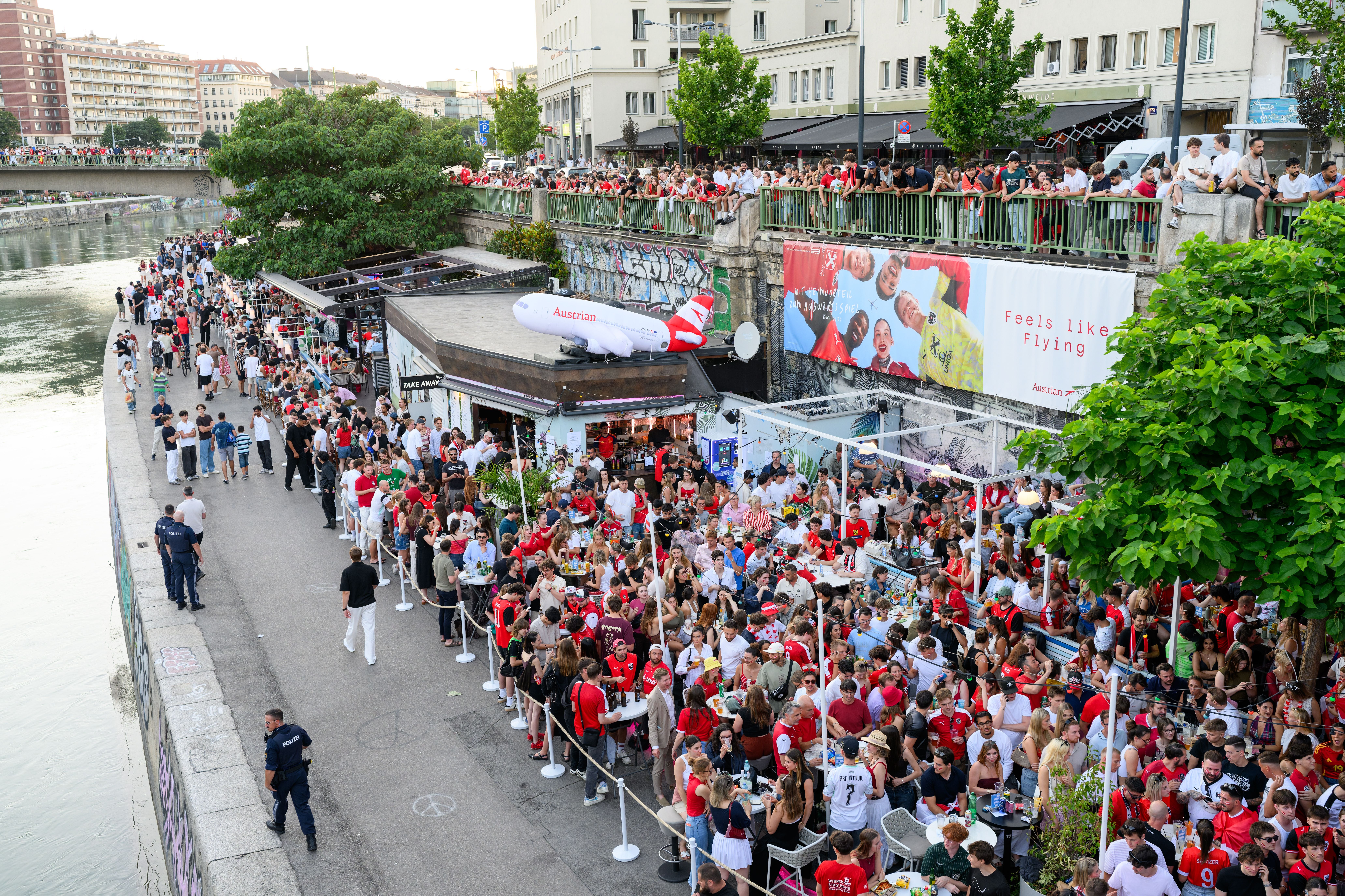 Viele Fans in roten Trikots feiern beim Public Viewing am Donaukanal in Wien zur Fußball-WM.