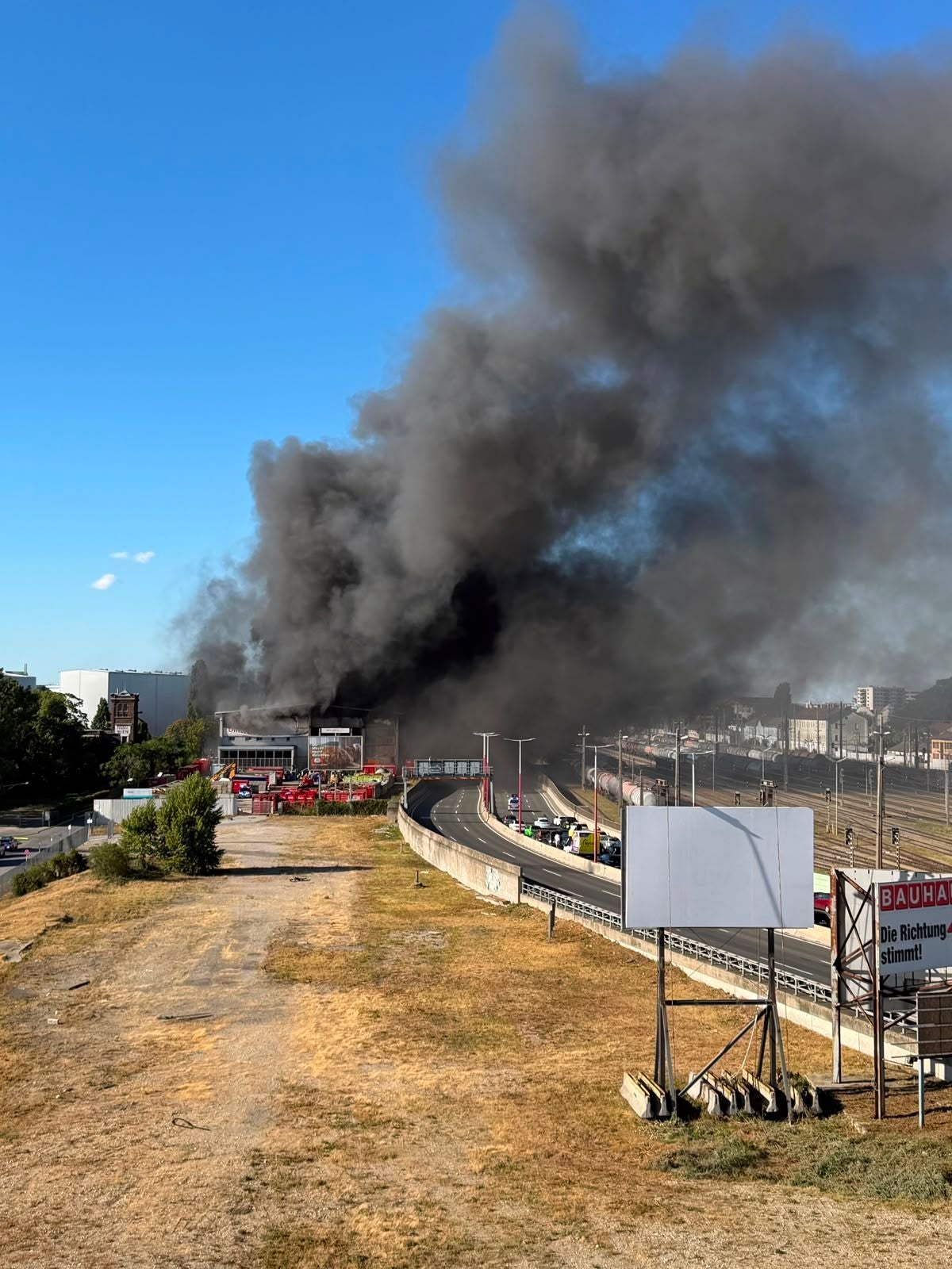 Dichte schwarze Rauchwolke steigt über einem brennenden Gebäude in Stadlau auf.