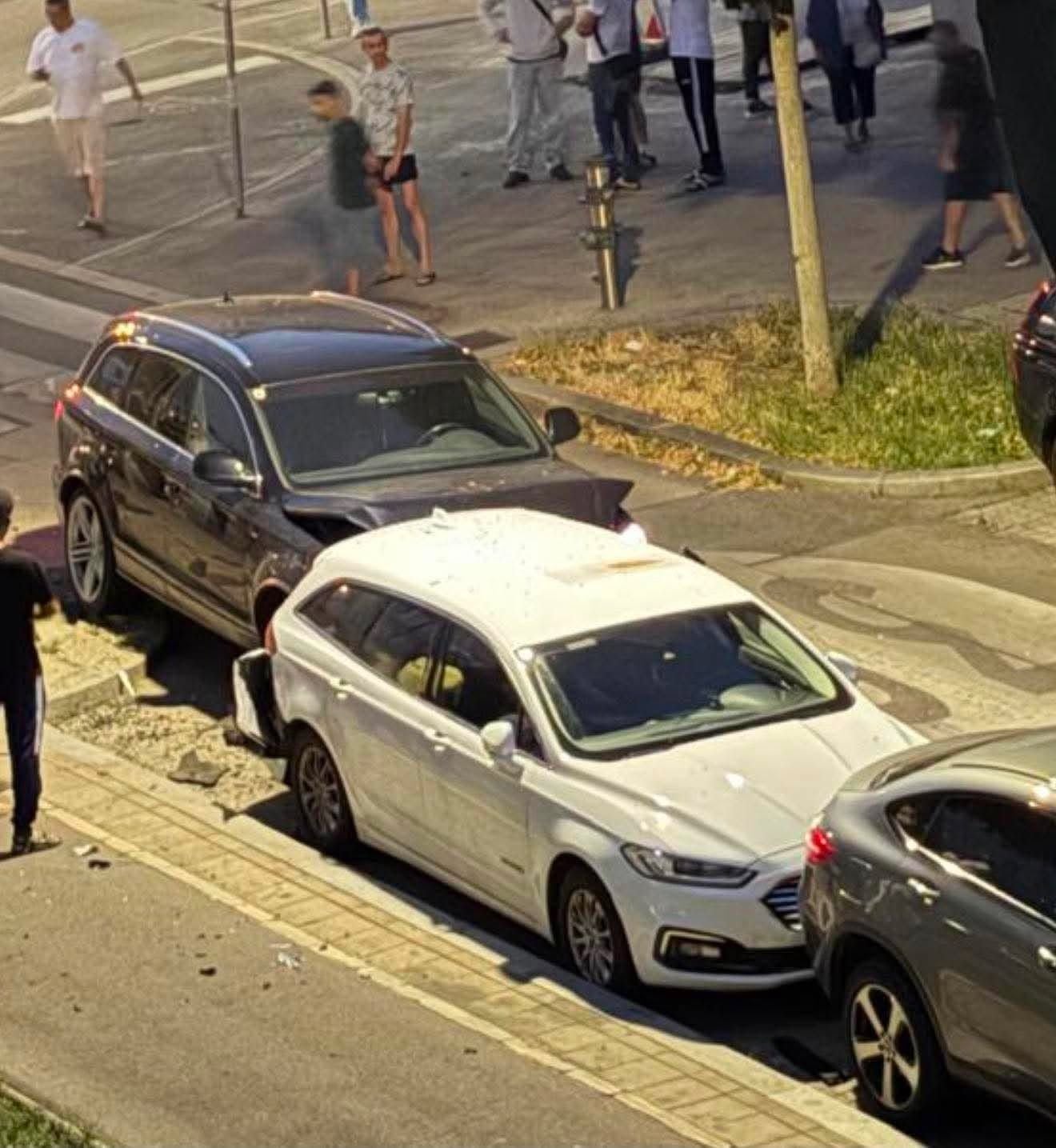 Drei Autos in einem Auffahrunfall, mehrere Menschen stehen als Zeugen am Straßenrand.