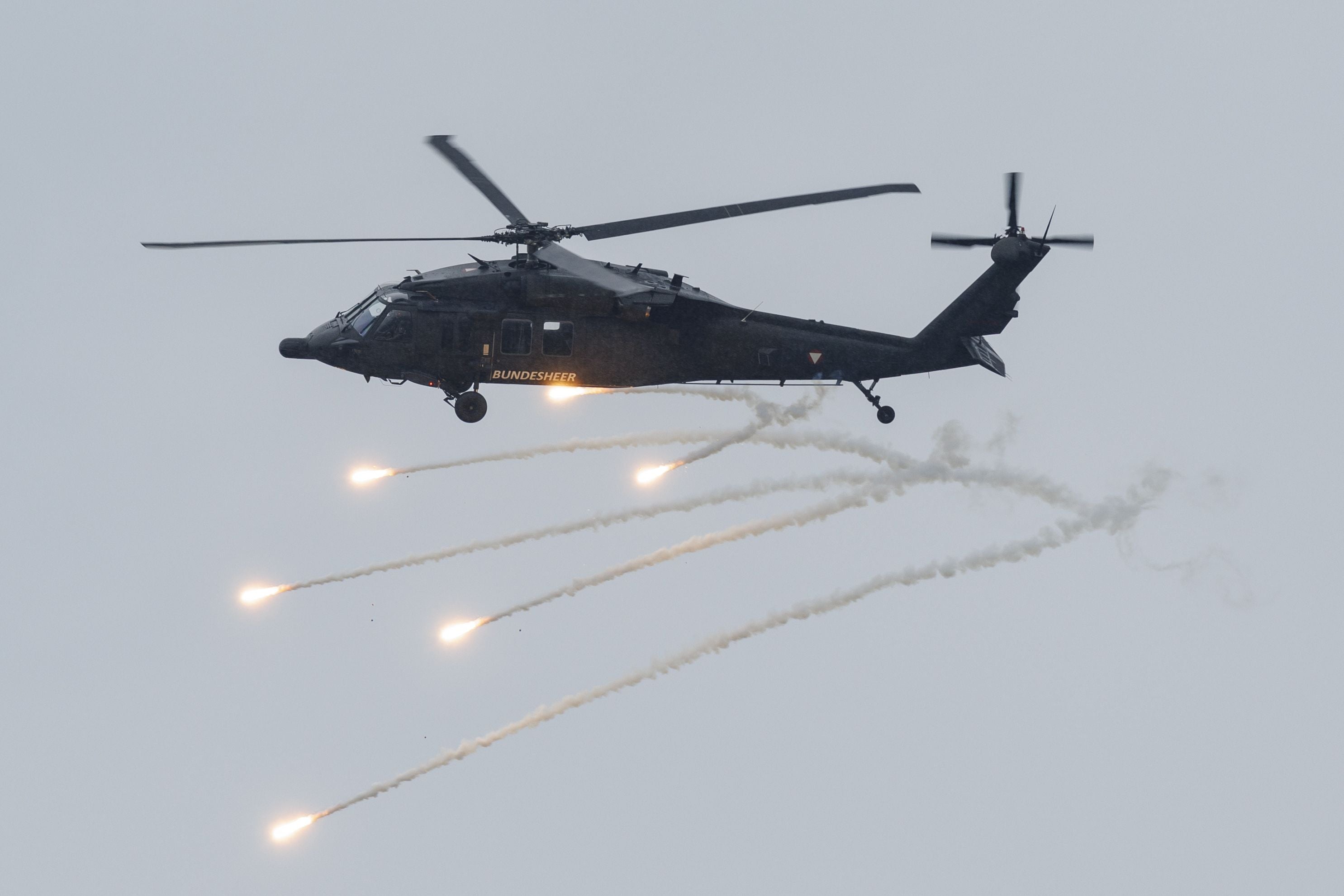 Ein österreichischer Blackhawk-Hubschrauber feuert Täuschkörper bei einer Flugshow ab.