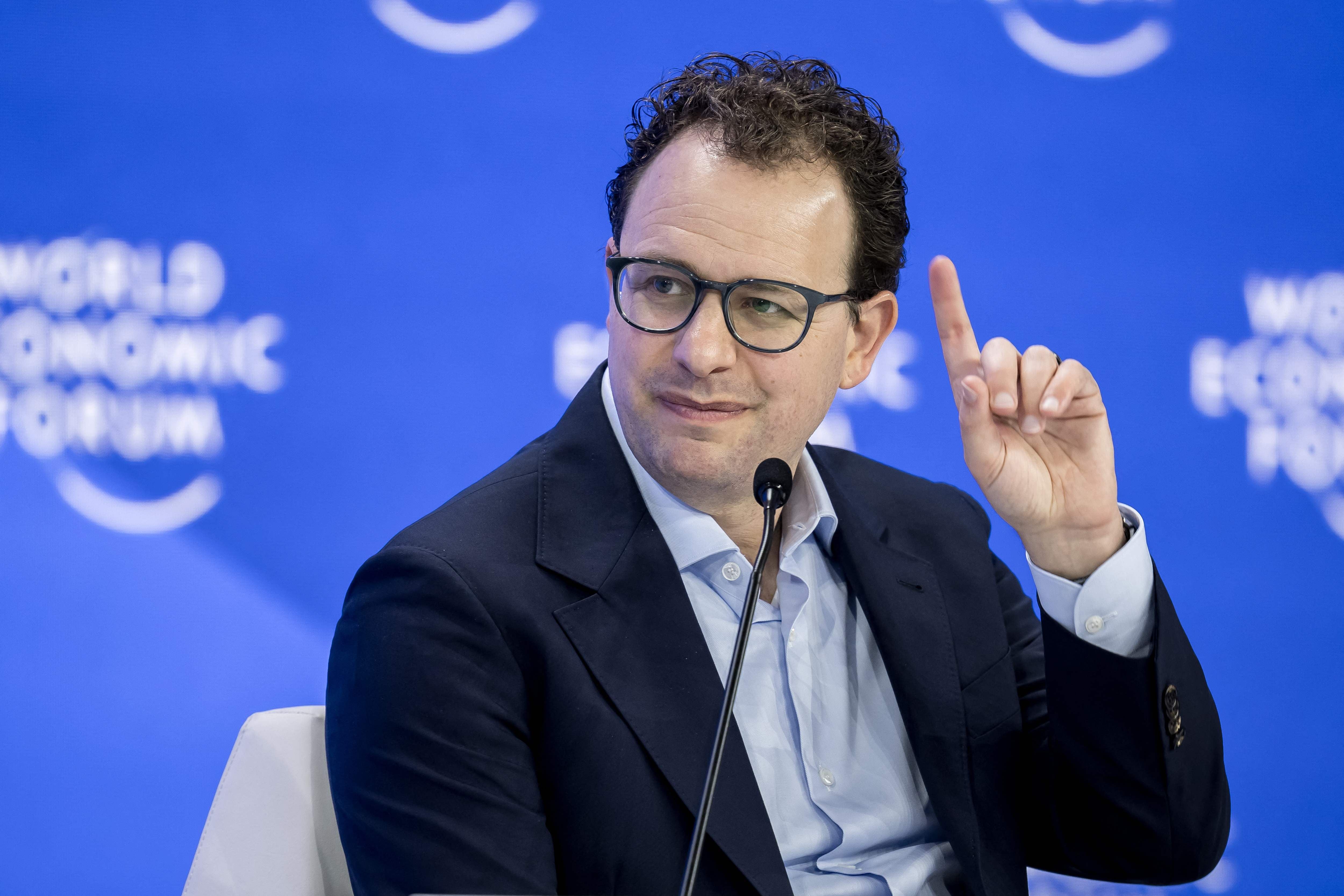 Ein Mann mit Brille spricht auf einer Bühne beim Weltwirtschaftsforum und hebt einen Finger.