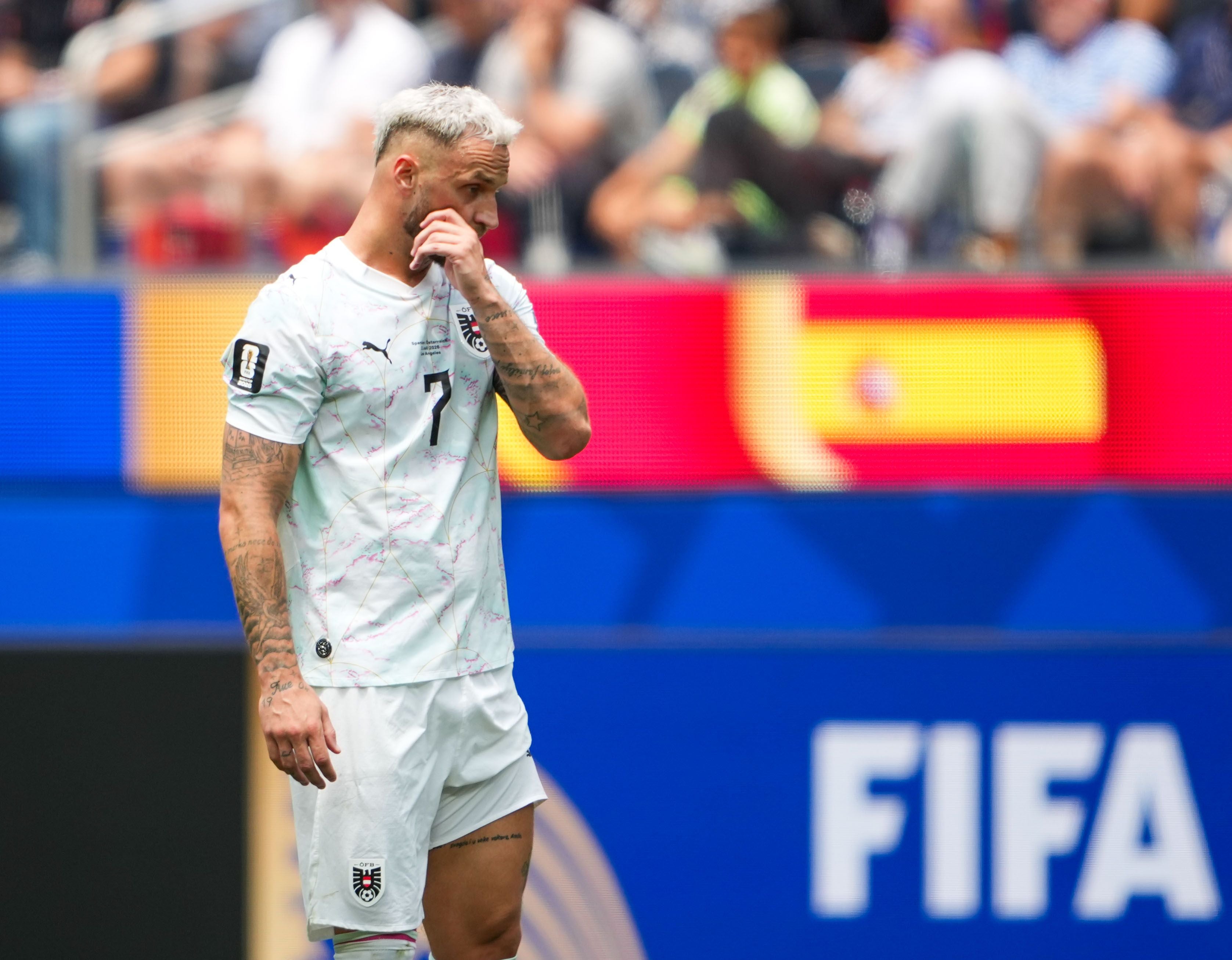 Ein österreichischer Fußballspieler steht nachdenklich auf dem Spielfeld bei der FIFA-WM 2026.