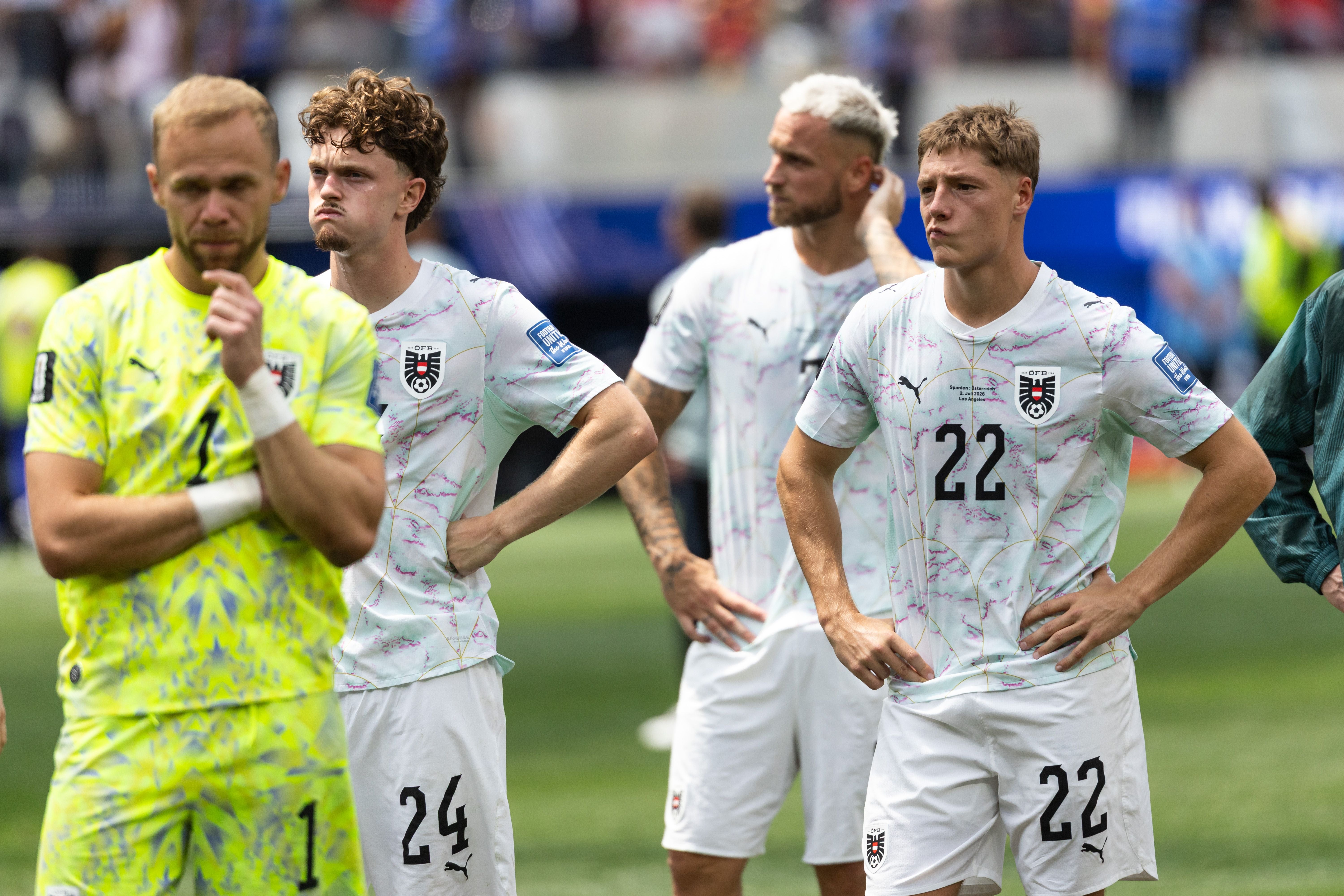 Vier österreichische Fußballspieler stehen enttäuscht auf dem Spielfeld nach einem WM-Spiel.