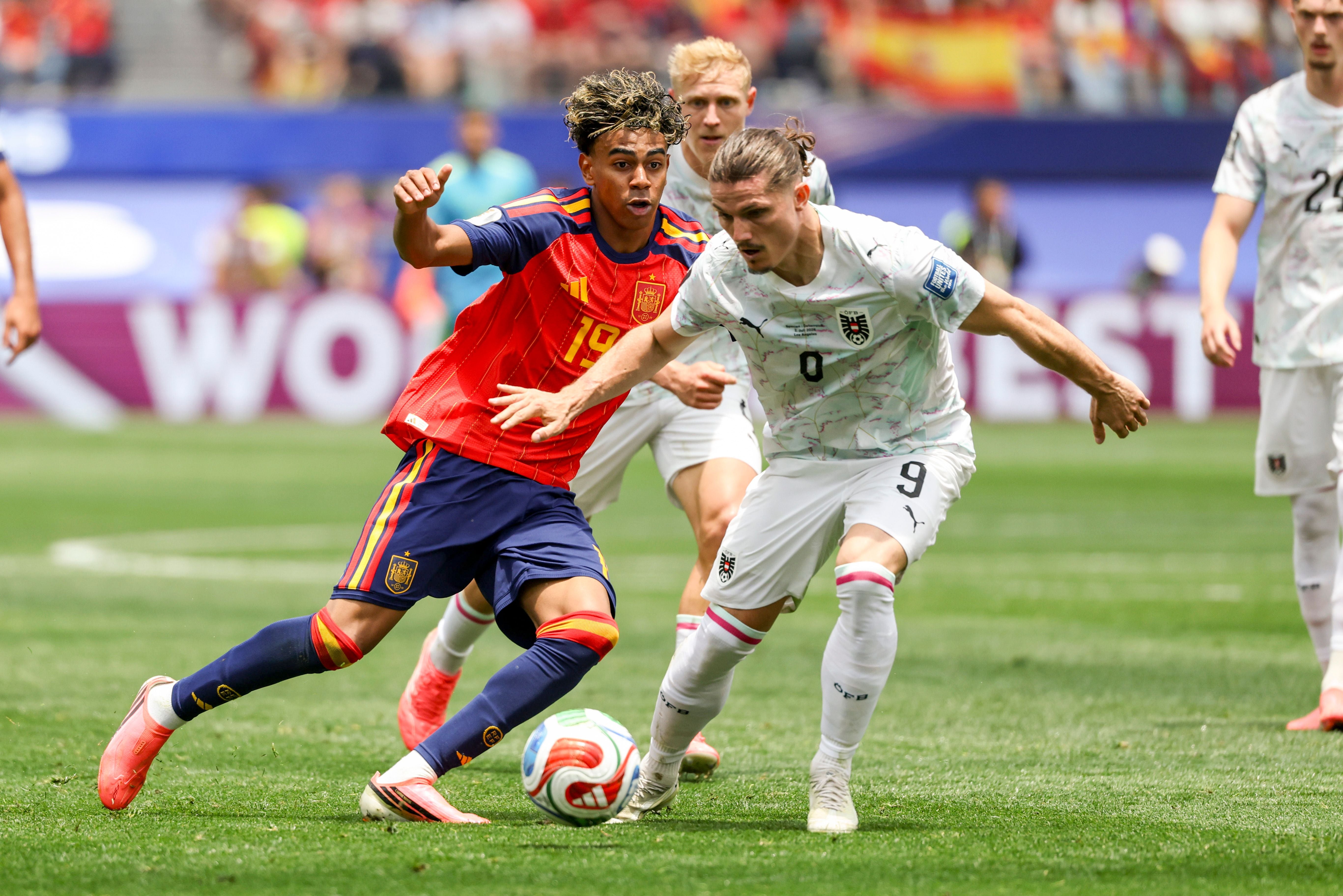 Zwei Fußballspieler aus Spanien und Österreich kämpfen um den Ball bei einem WM-Spiel.