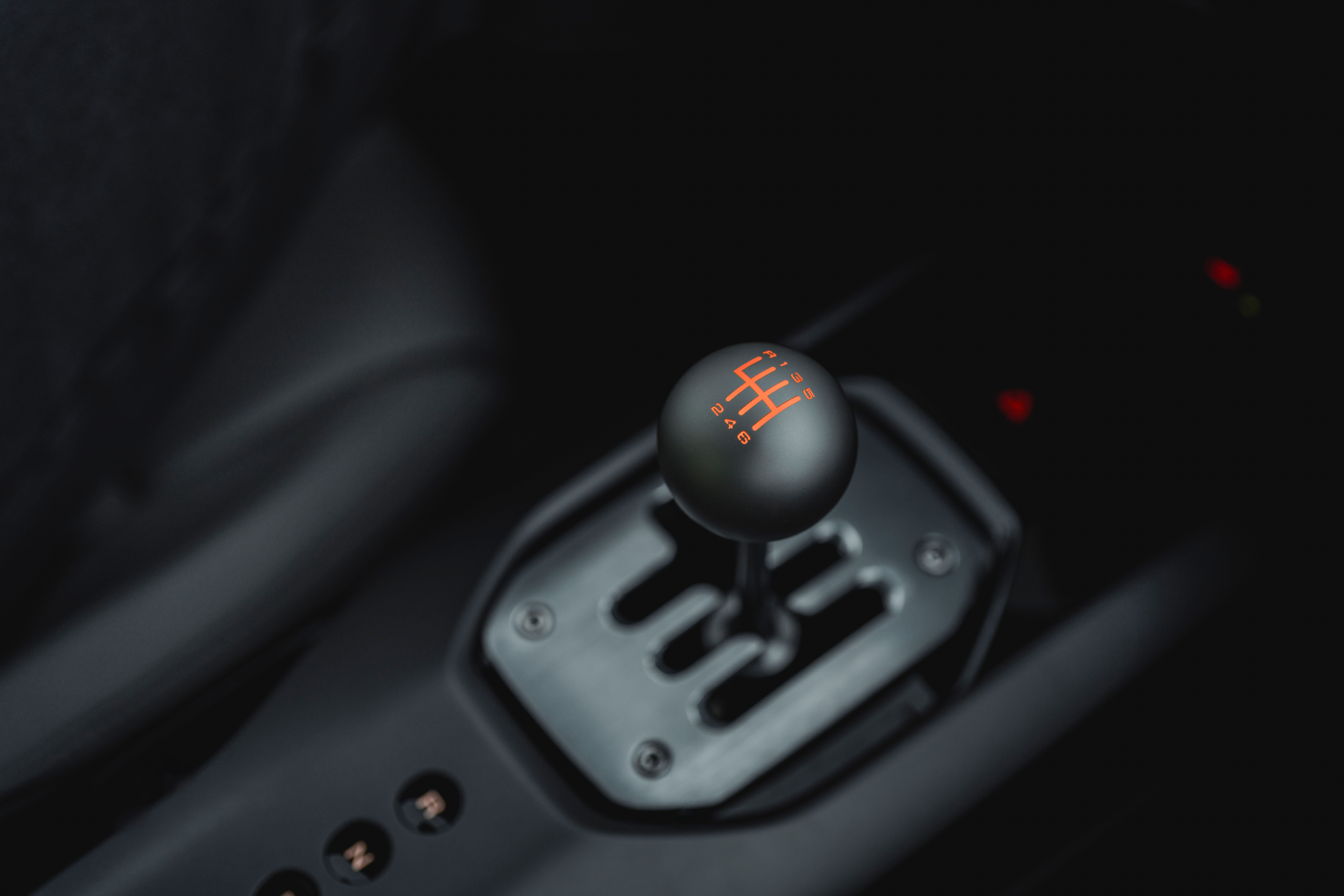 Schaltknauf eines Ferrari mit eingeprägtem Schaltschema in roter Farbe.