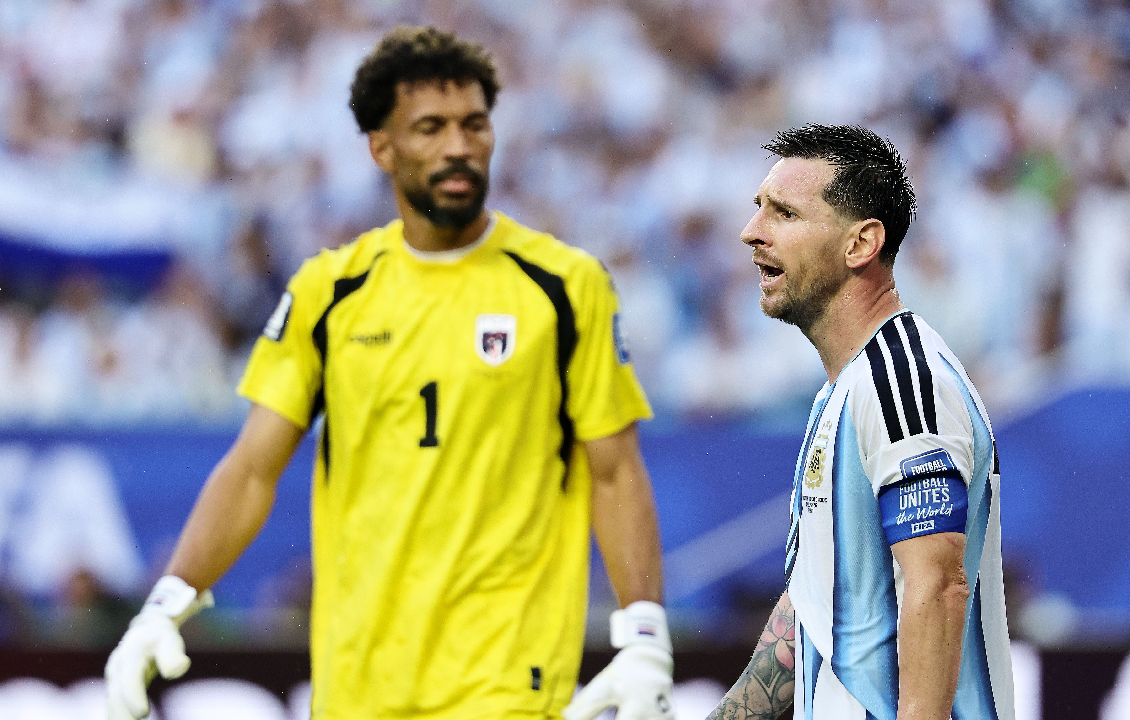 Zwei Fußballspieler, einer im argentinischen Trikot, während eines WM-Spiels auf dem Spielfeld.