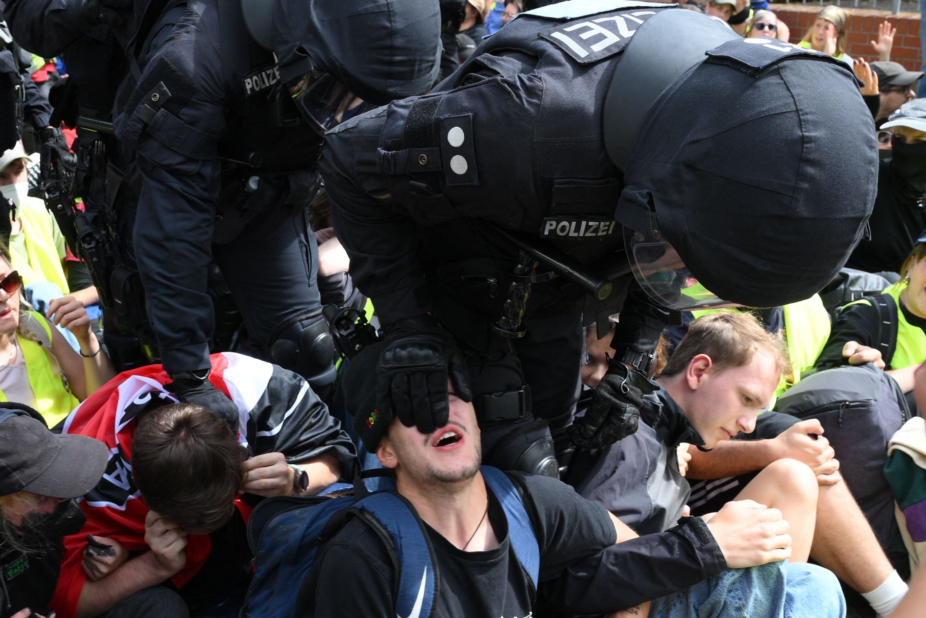 Polizisten halten Demonstrierende auf einer Straße bei einer Sitzblockade in Erfurt fest.