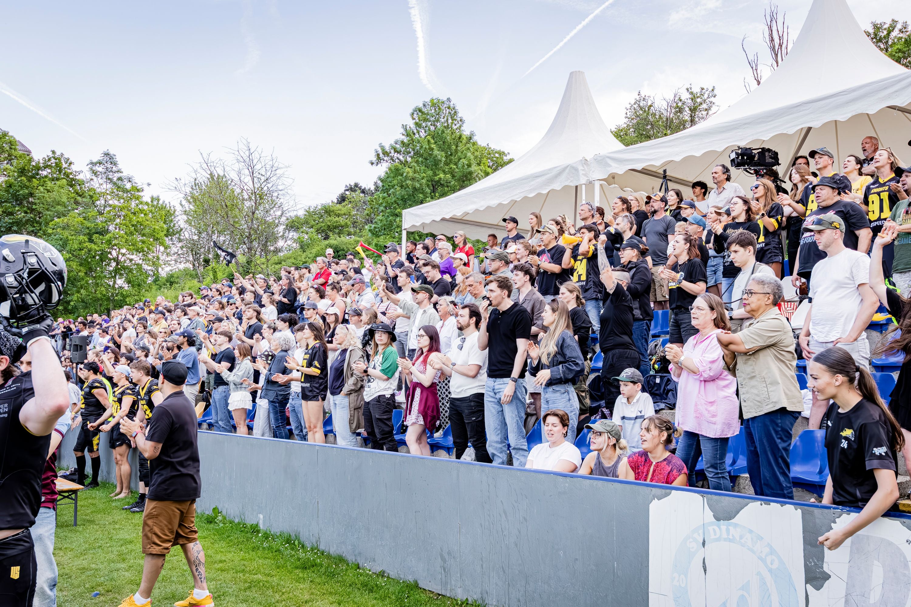 Eine große Menschenmenge jubelt auf der Tribüne bei einem Vikings-Knights-Spiel im Freien.