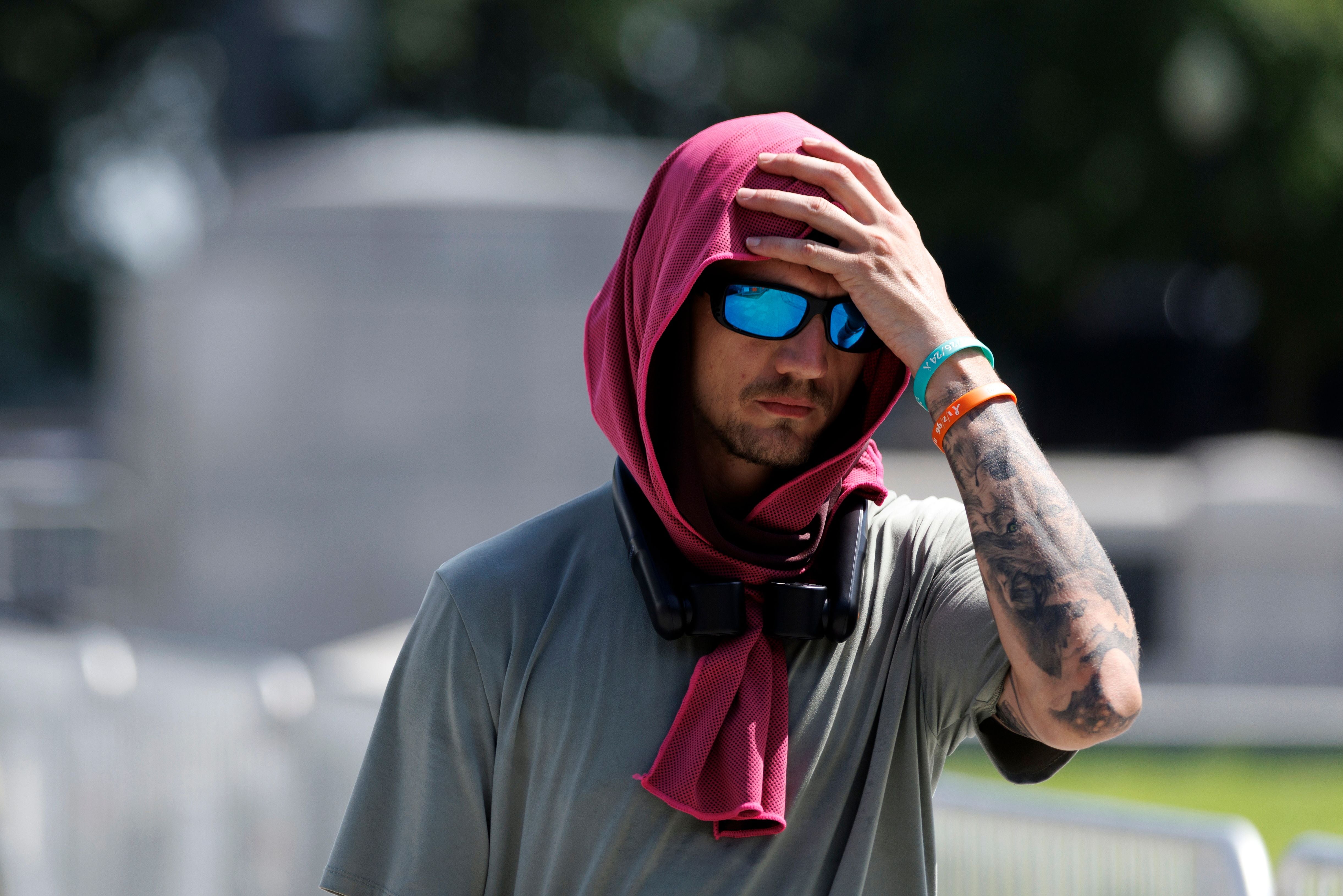 Mann mit Sonnenbrille und pinkem Tuch schützt sich in Hitze in Washington, DC.