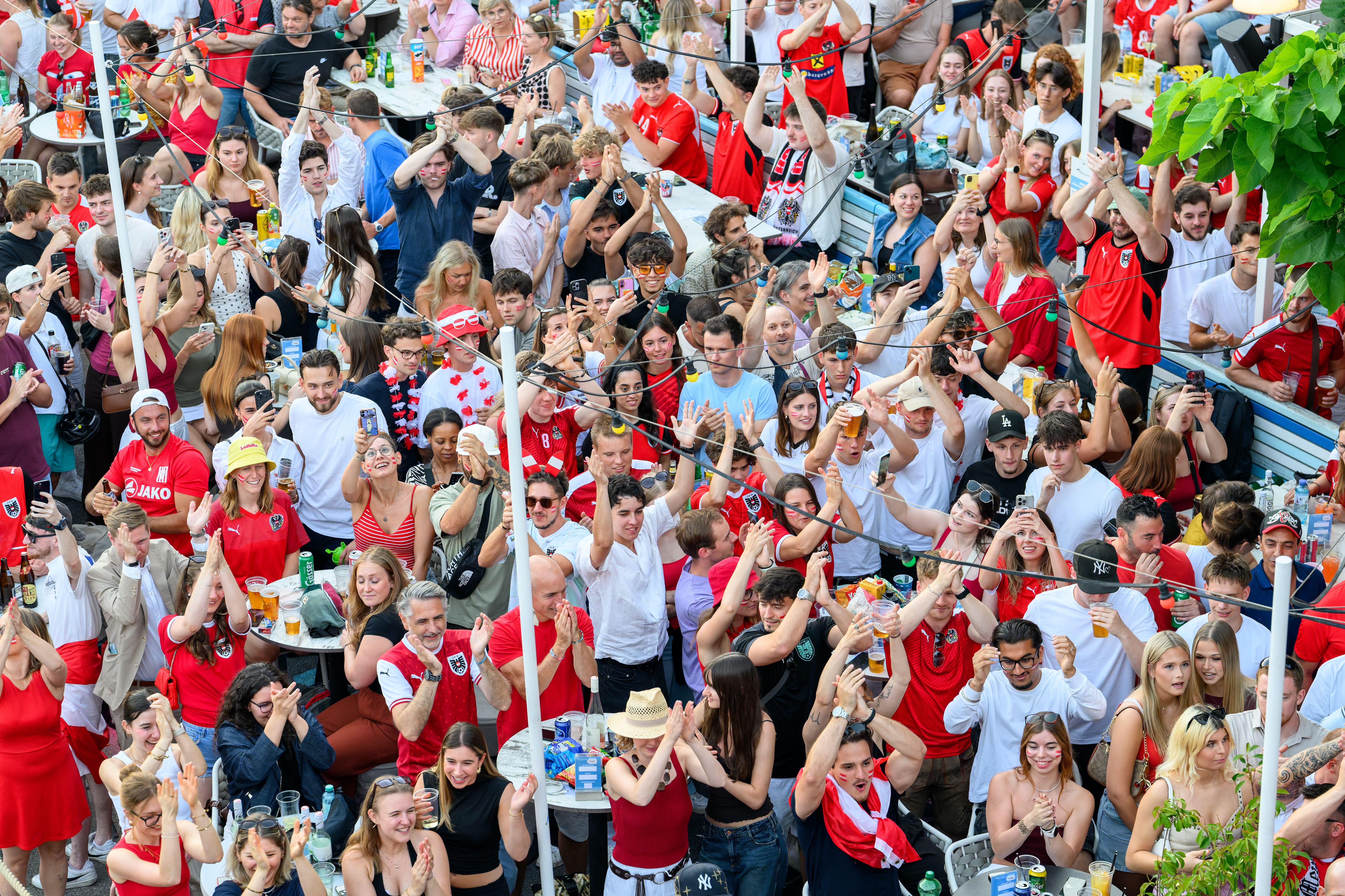 Große Menschenmenge jubelt beim Public Viewing eines Fußballspiels in Wien am Donaukanal.