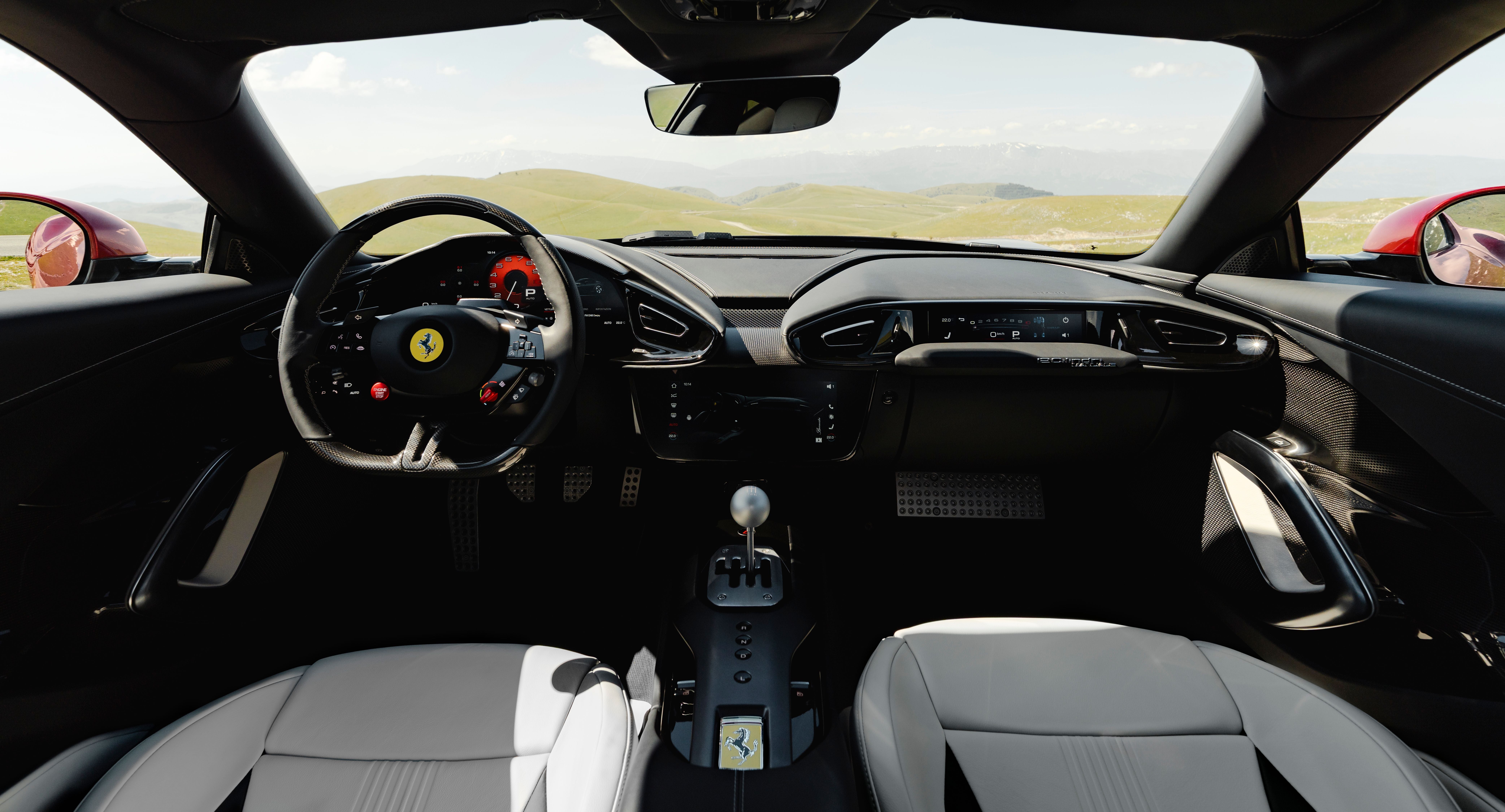 Modernes Ferrari-Cockpit mit Ledersitzen, Sportlenkrad und Schaltknüppel, Blick auf grüne Hügel.