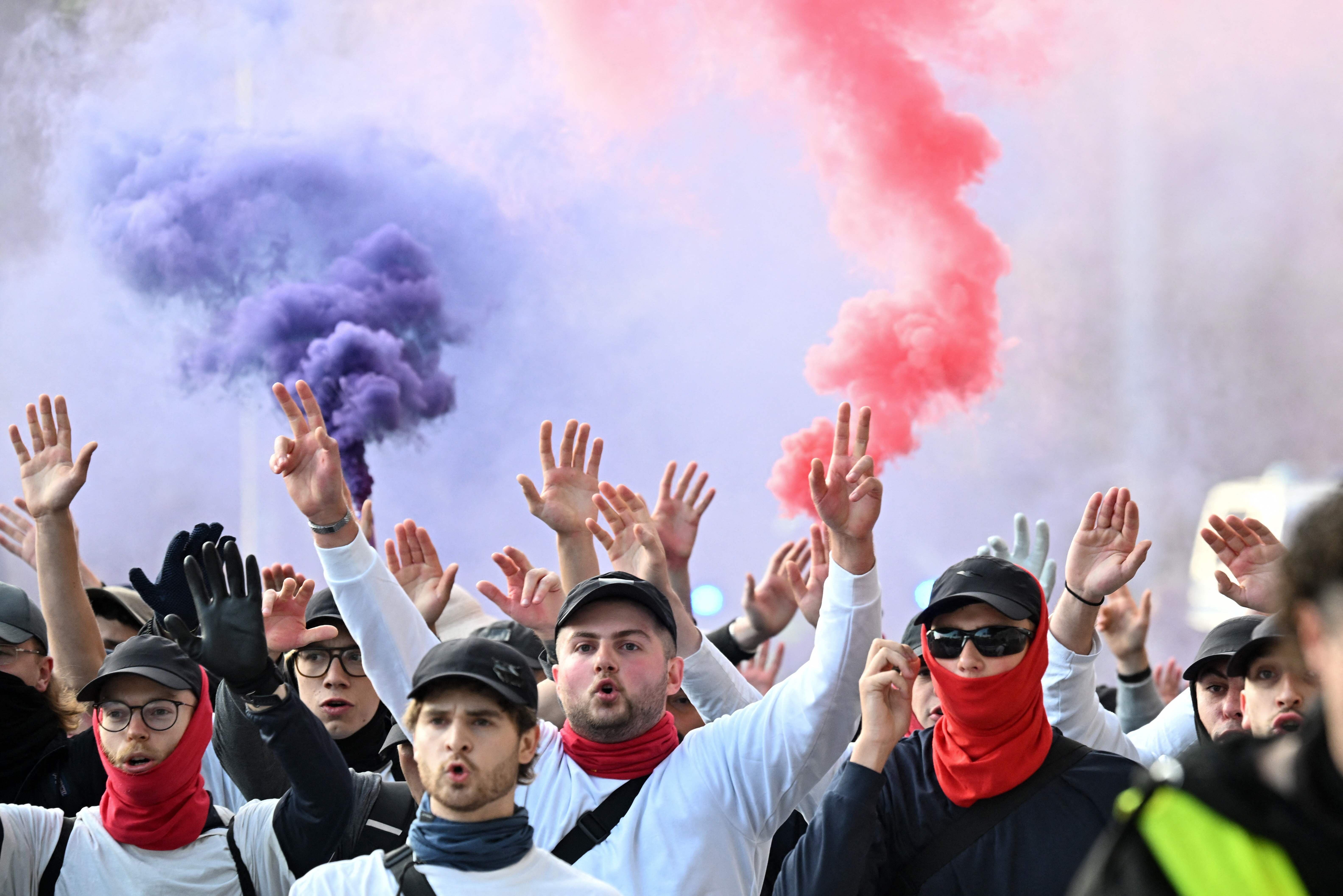 Demonstranten mit erhobenen Händen und Rauchfackeln bei einem Protest in Erfurt, Deutschland.