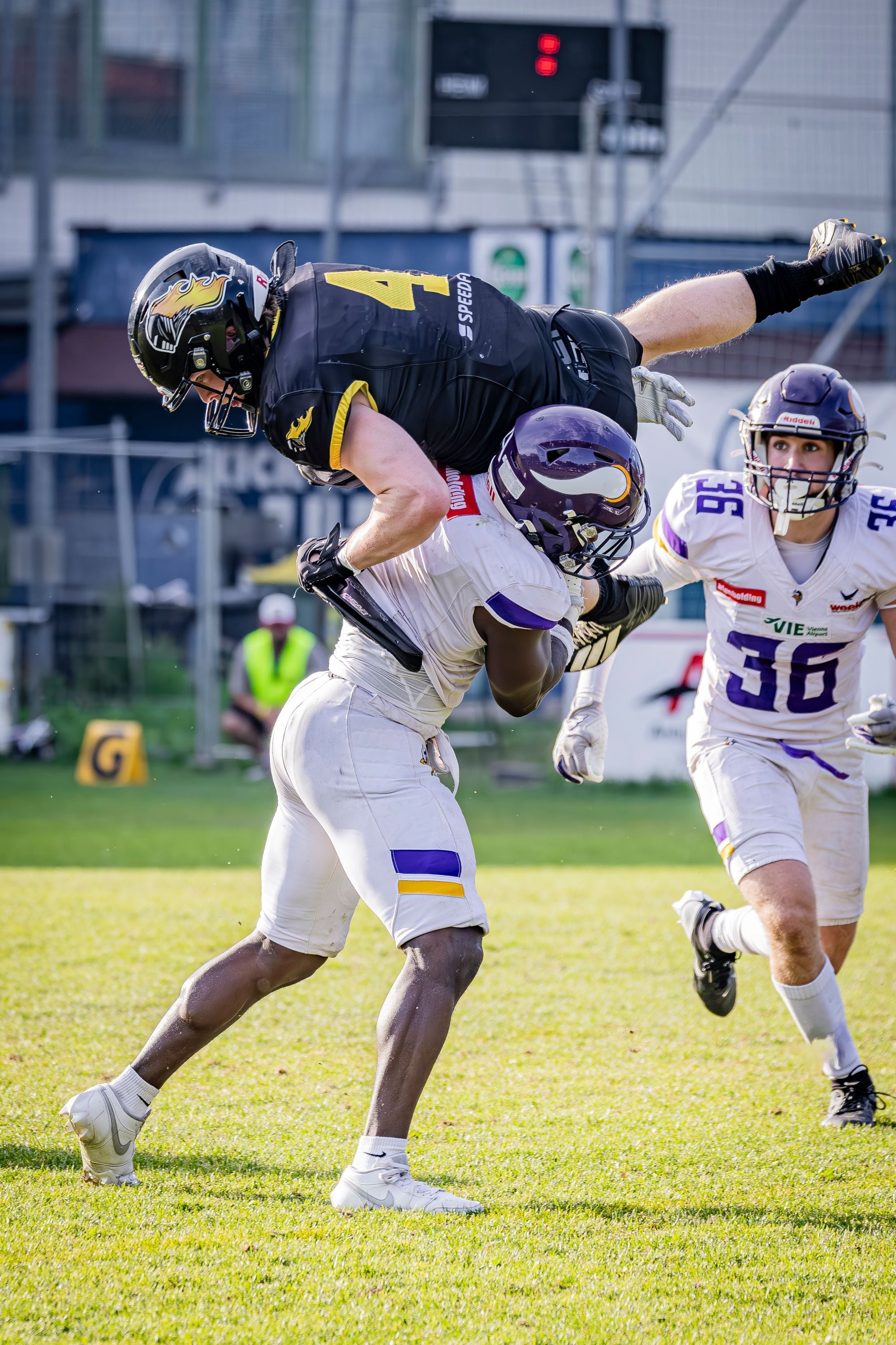 Ein Vikings-Spieler tackelt einen Knights-Spieler im American Football Spiel auf dem Spielfeld.