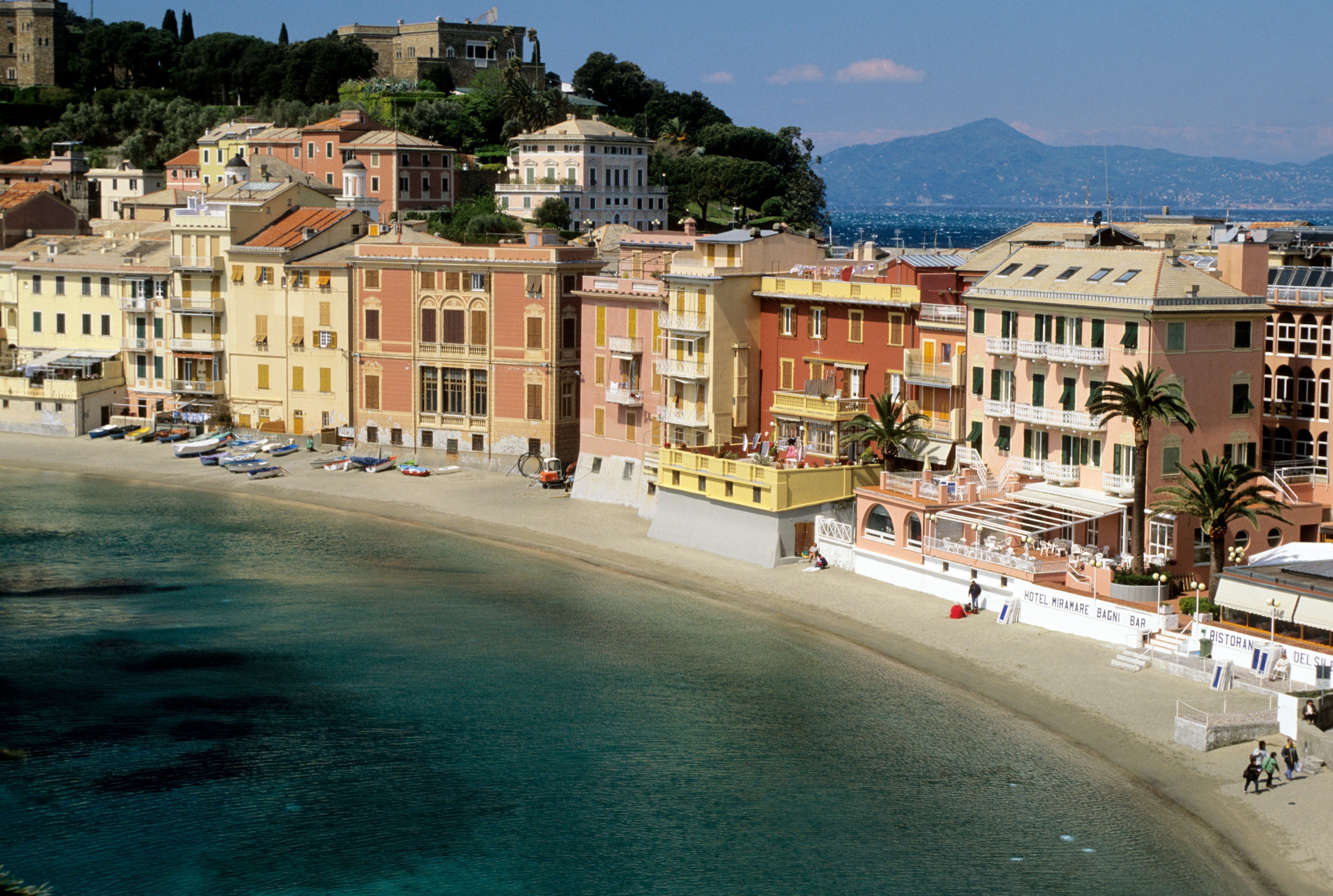 Bunte Häuser am Sandstrand der Baia del Silenzio in Sestri Levante, Ligurien, Italien.