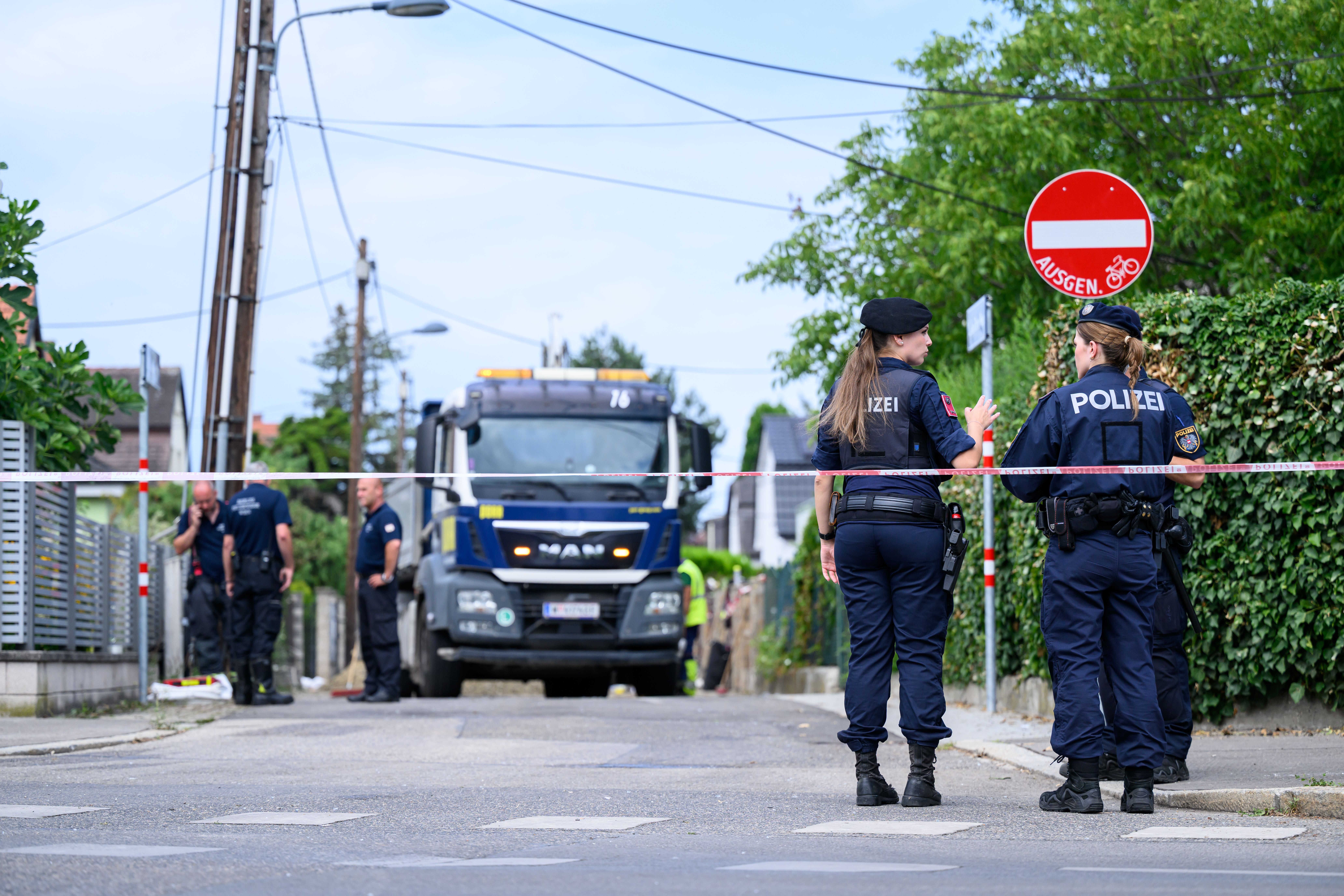 Polizistinnen und Einsatzkräfte sperren eine Straße nach einer Explosion in Wien-Floridsdorf ab.