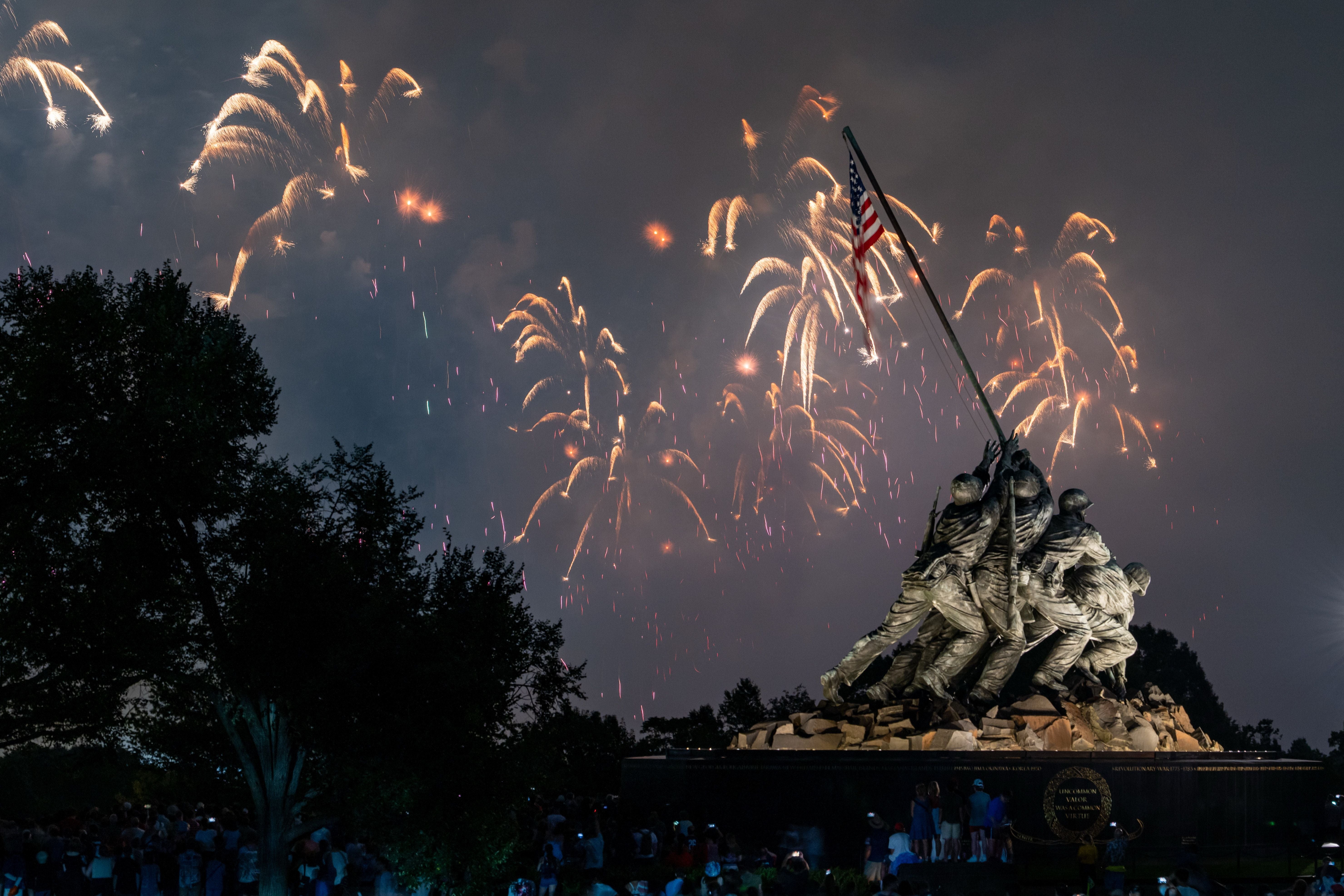 Feuerwerk über dem Iwo-Jima-Memorial bei Nacht mit Menschenmenge im Vordergrund.