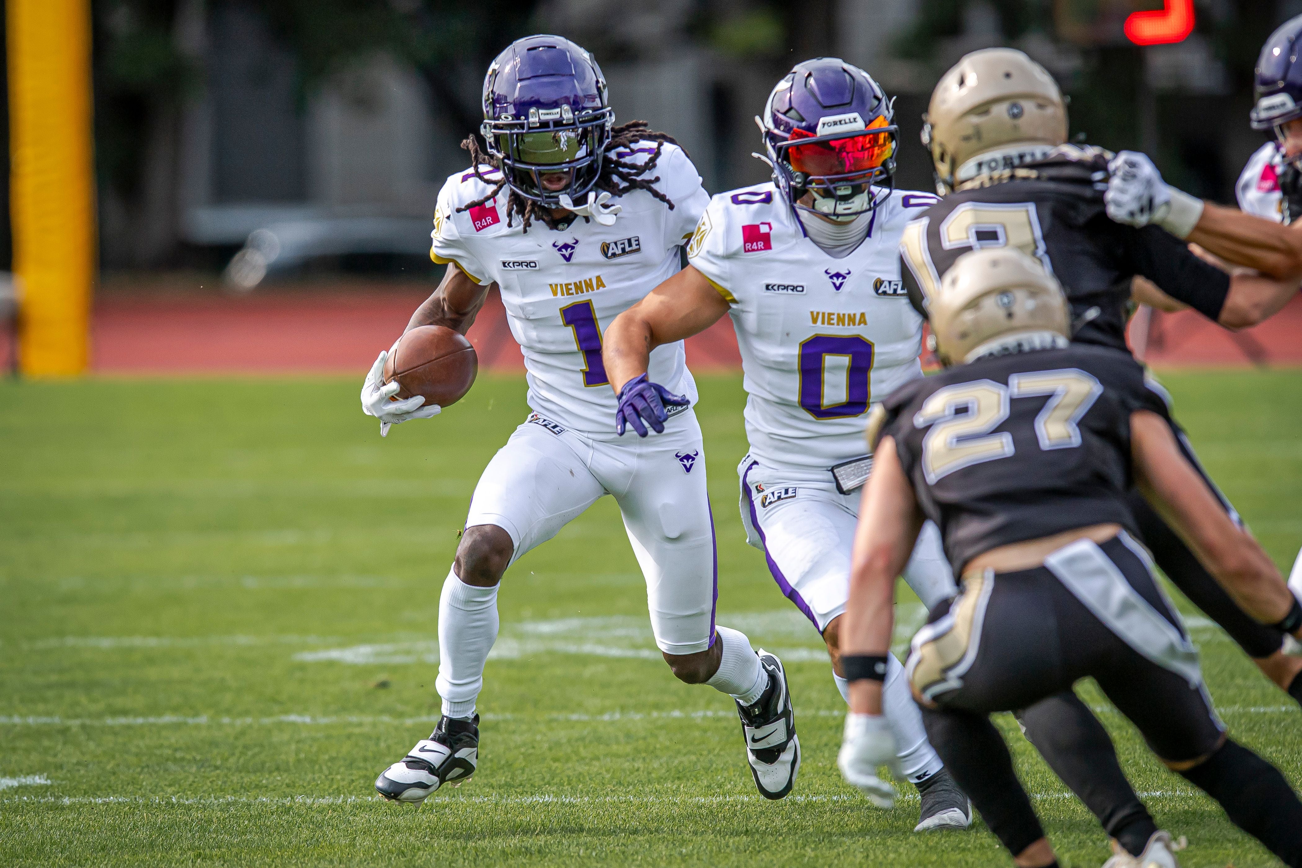 American-Football-Spieler der Vienna Vikings im Angriff gegen Spieler der Thunder auf dem Spielfeld.