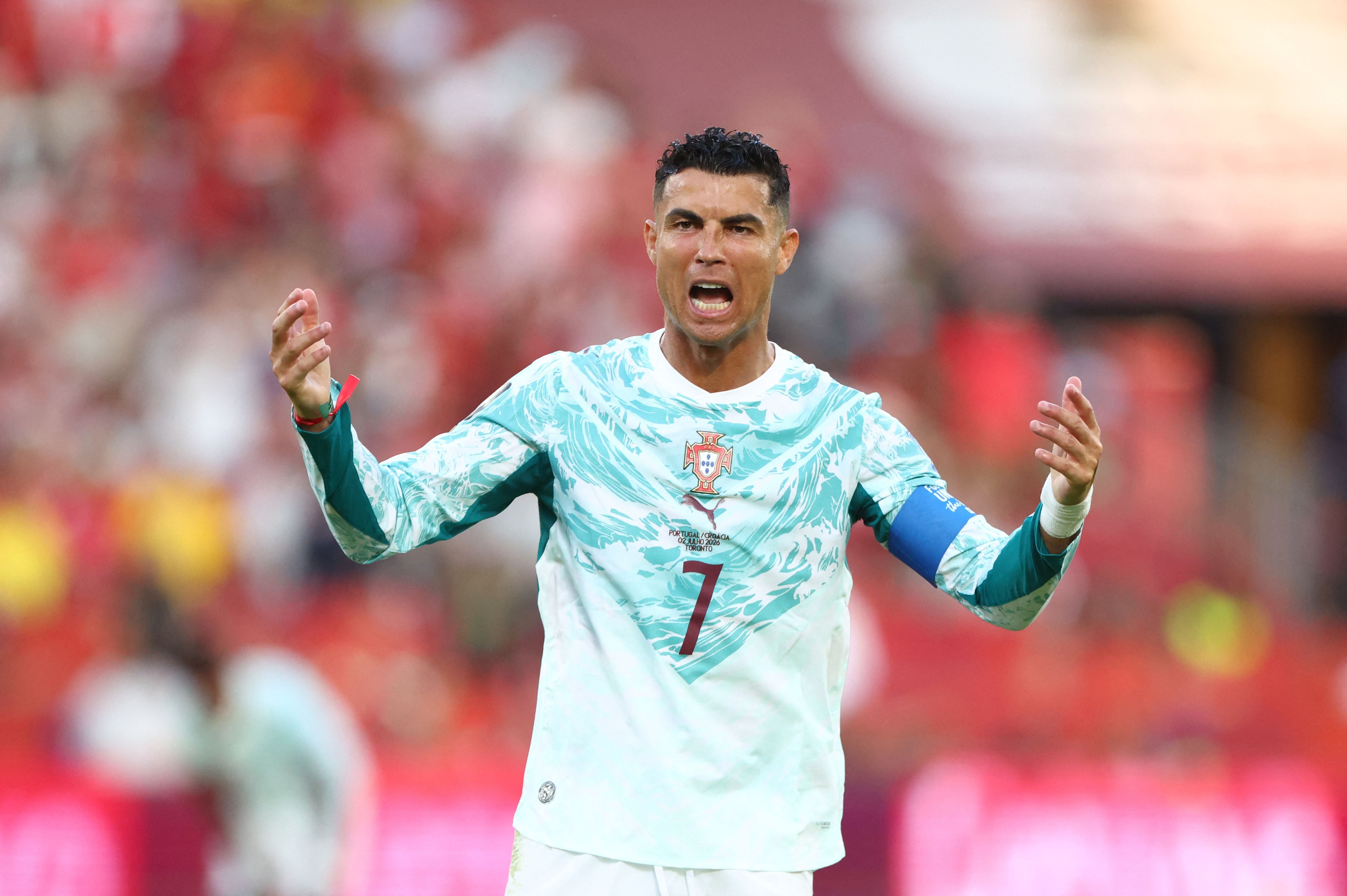 Ein portugiesischer Fußballspieler mit weiß-blauem Trikot gestikuliert emotional auf dem Spielfeld.