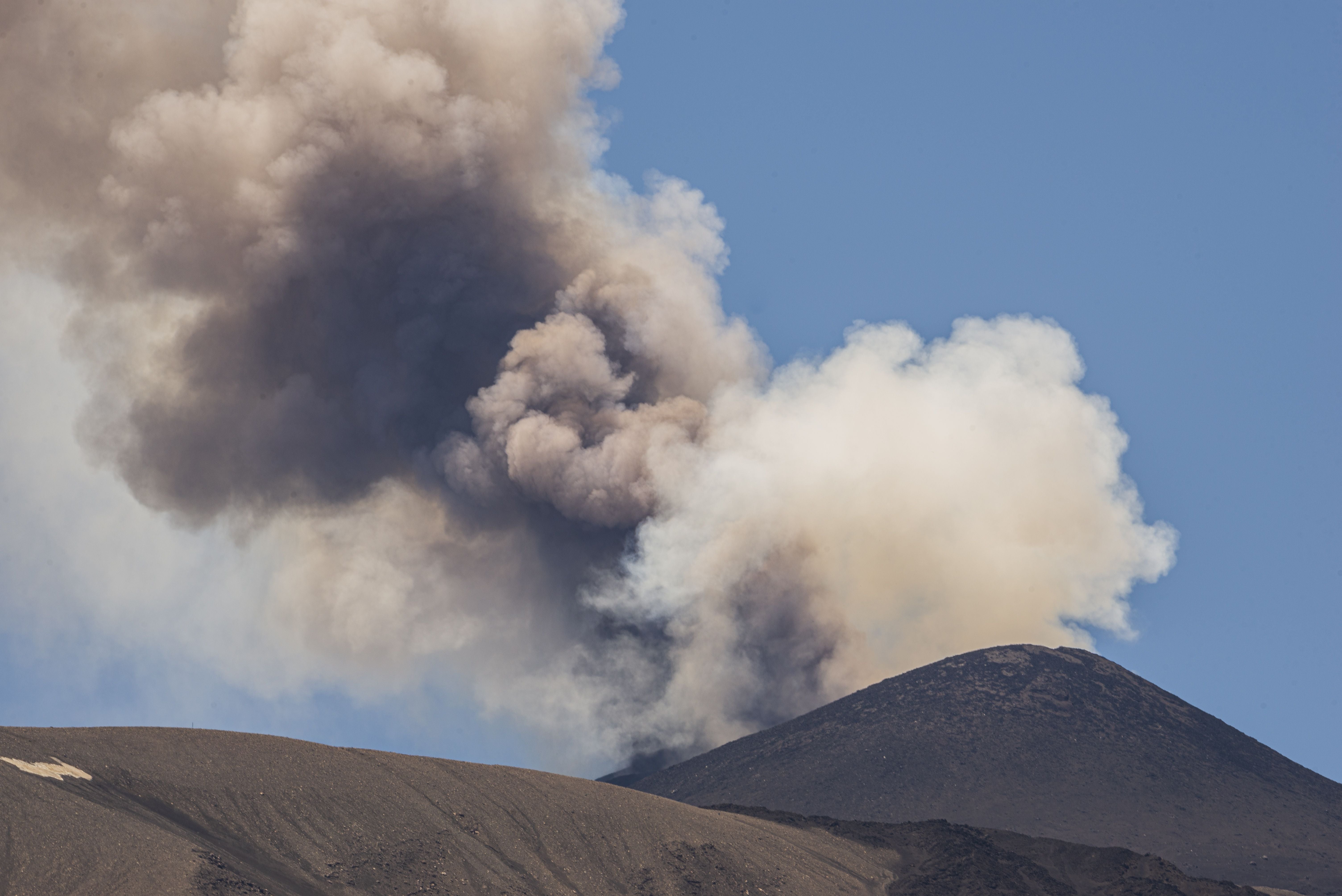 CATANIA, ITALY - JULY 5: A towering ash plume rises from Mount Etna following the resumption of eruptive activity from a vent located on the upper eastern flank of the Voragine summit crater as the Volcano Observatory Notice for Aviation (VONA) remains at RED alert level in Catania, Sicily, Italy, on July 5, 2026. The ash emission generated an eruption column reaching approximately 1.5 kilometres above the volcano's summit, drifting toward the south and south-southeast. The effusive lava flow, which had been active since June 26, ceased on July 4, while Strombolian activity continues at the summit vent. The presence of volcanic ash prompted temporary airspace restrictions south of the volcano, affecting operations at Catania Airport. (Photo by Salvatore Allegra/Anadolu via Getty Images)