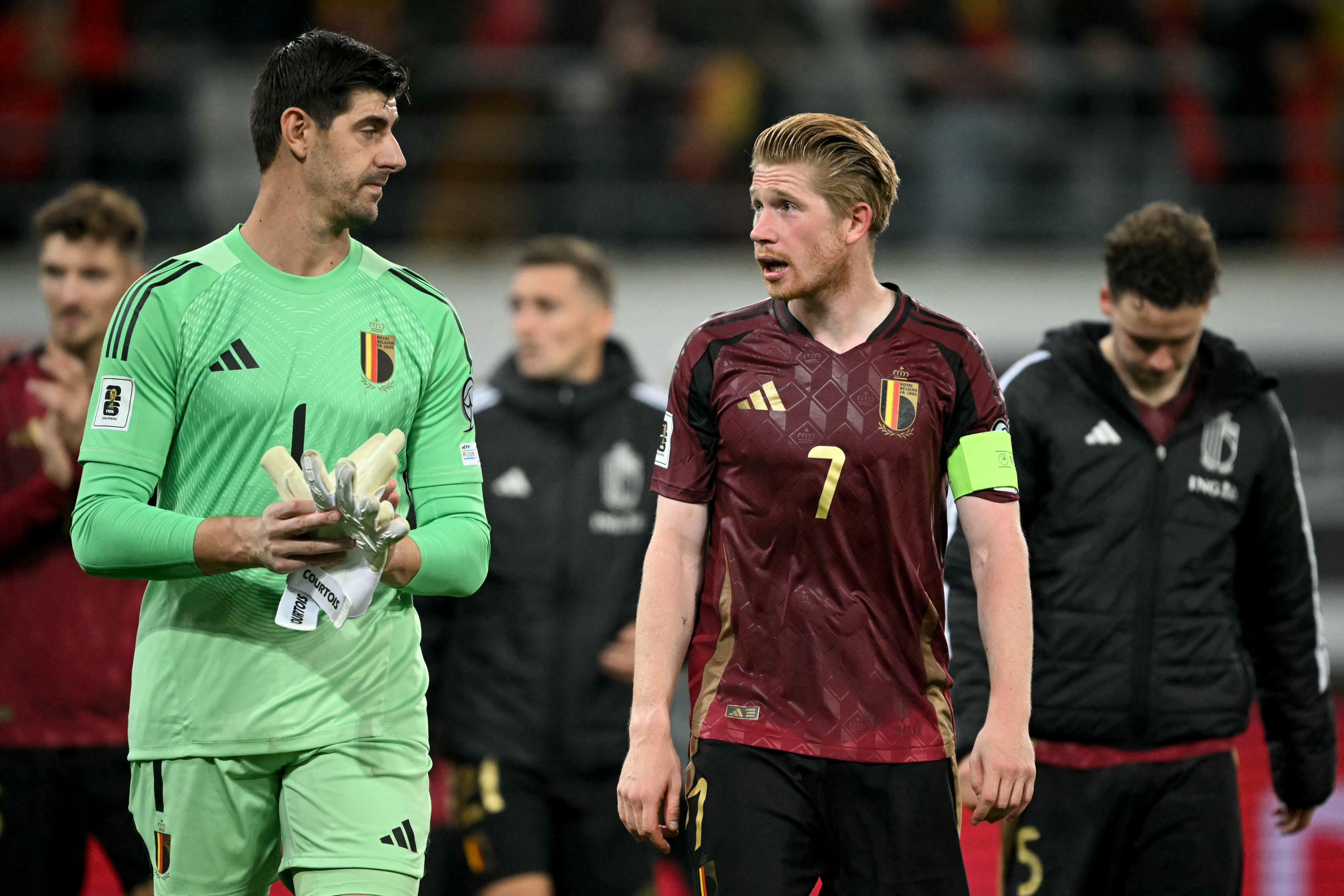 Zwei belgische Fußballspieler verlassen nach einem Spiel gemeinsam das Spielfeld.