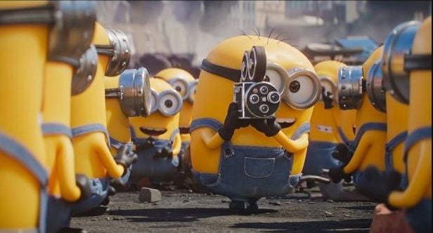 Mehrere Minions stehen zusammen, einer hält eine alte Filmkamera und filmt die anderen.