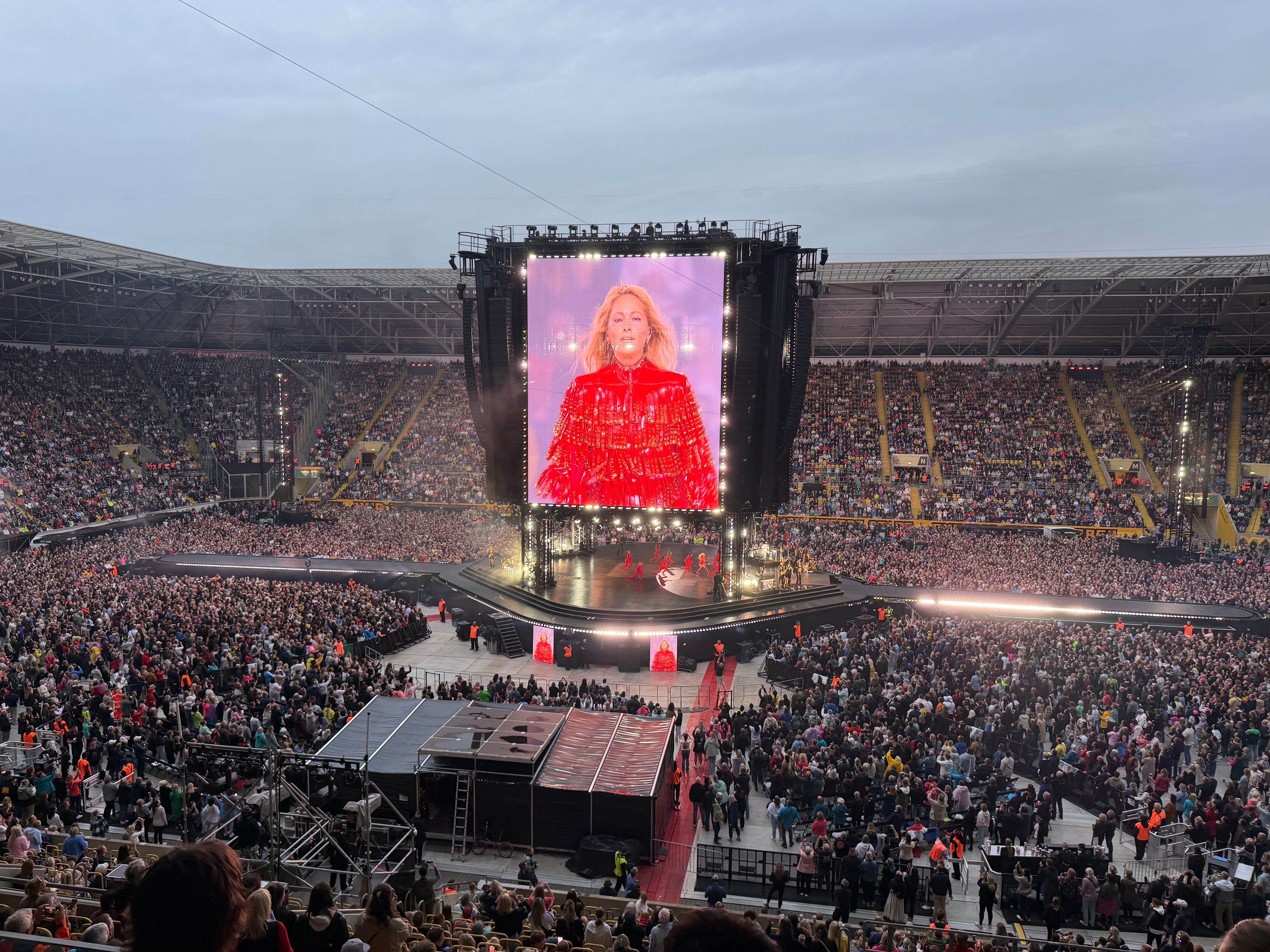 Großes Konzert im Stadion, Helene Fischer auf der Bühne mit rotem Outfit und riesiger Leinwand.
