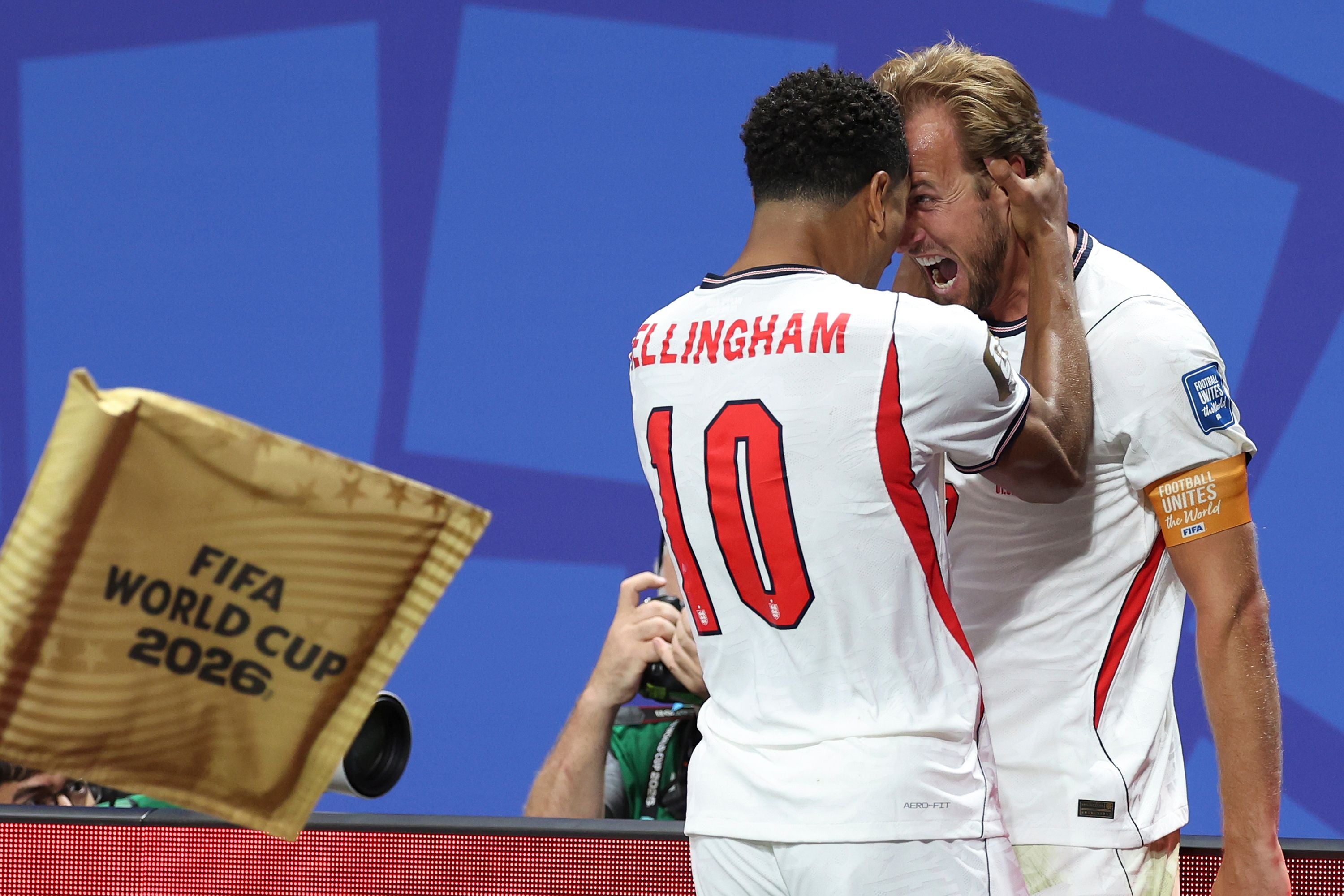 Harry Kane und Jude Bellingham jubeln beim WM-Spiel für England, im Vordergrund ein FIFA World Cup 2026 Banner.