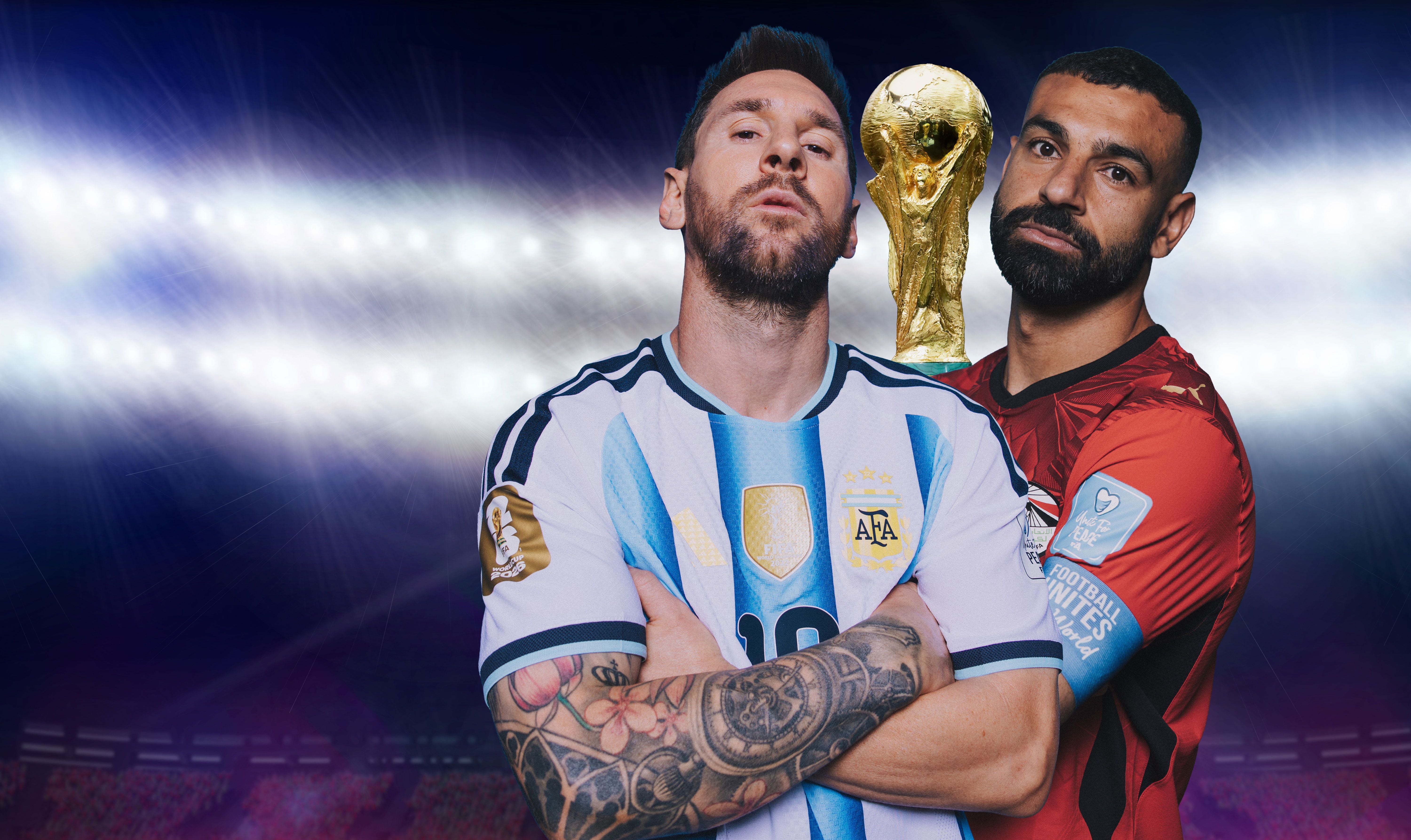 Zwei Fußballspieler aus Argentinien und Ägypten stehen vor einem WM-Pokal im Stadion.