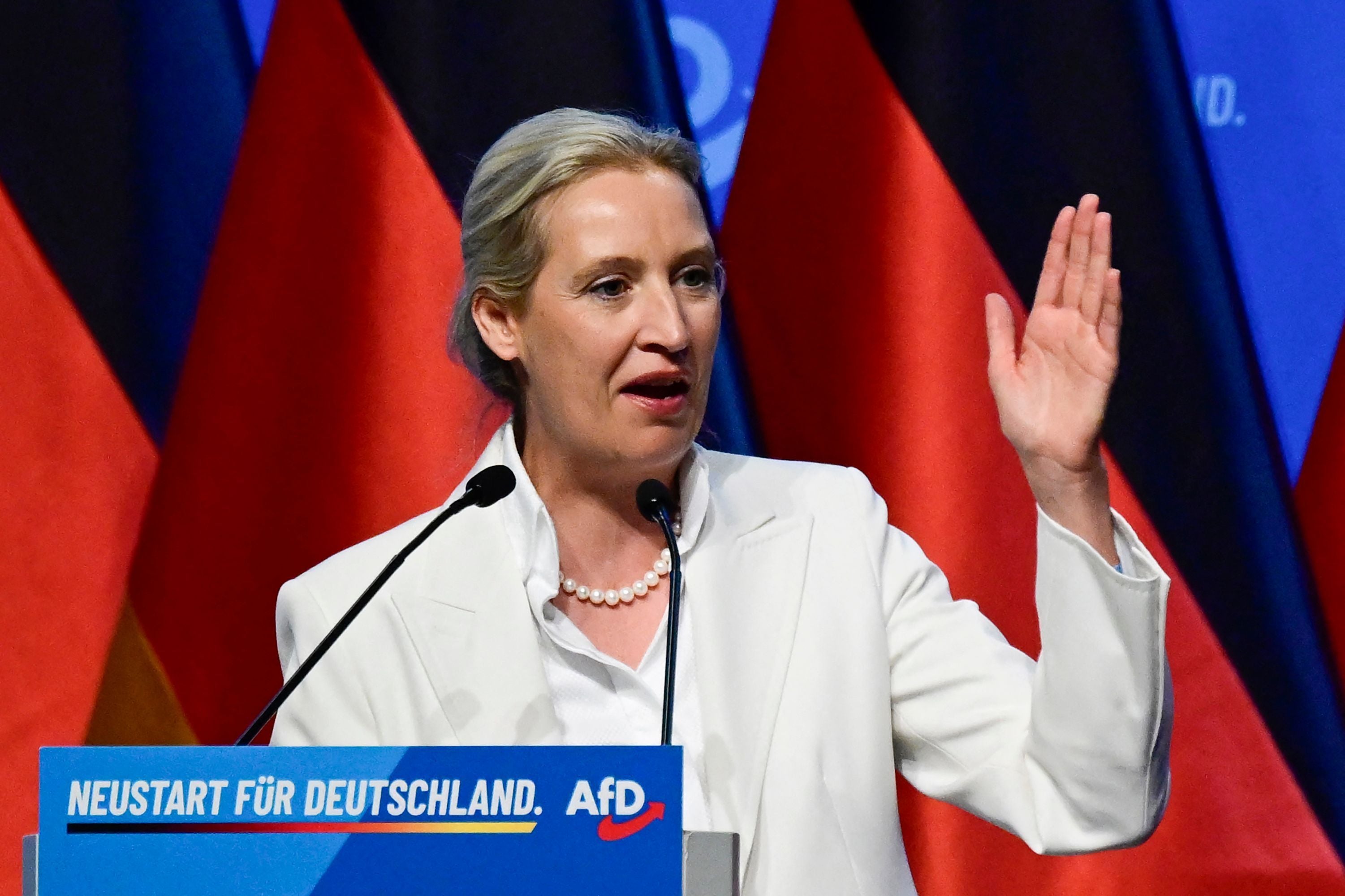 Eine Frau im weißen Anzug spricht am Rednerpult bei einer AfD-Veranstaltung in Erfurt.