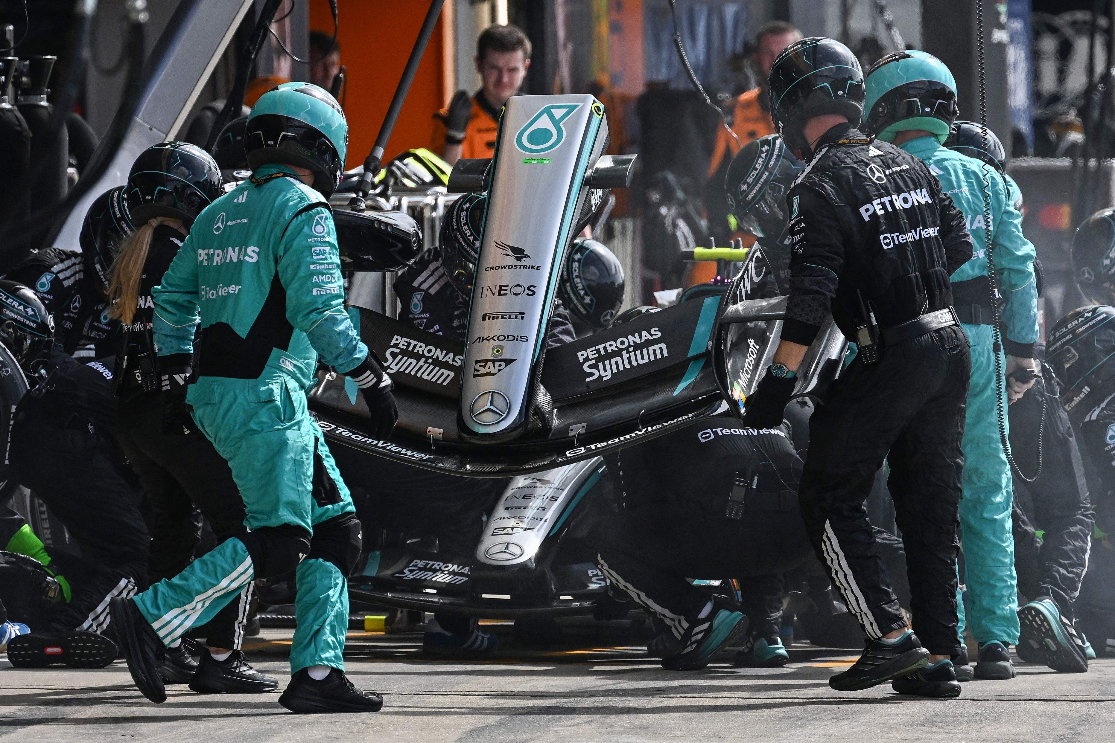 Mercedes-Mechaniker führen einen Boxenstopp mit Nasenwechsel an einem Formel-1-Auto durch.