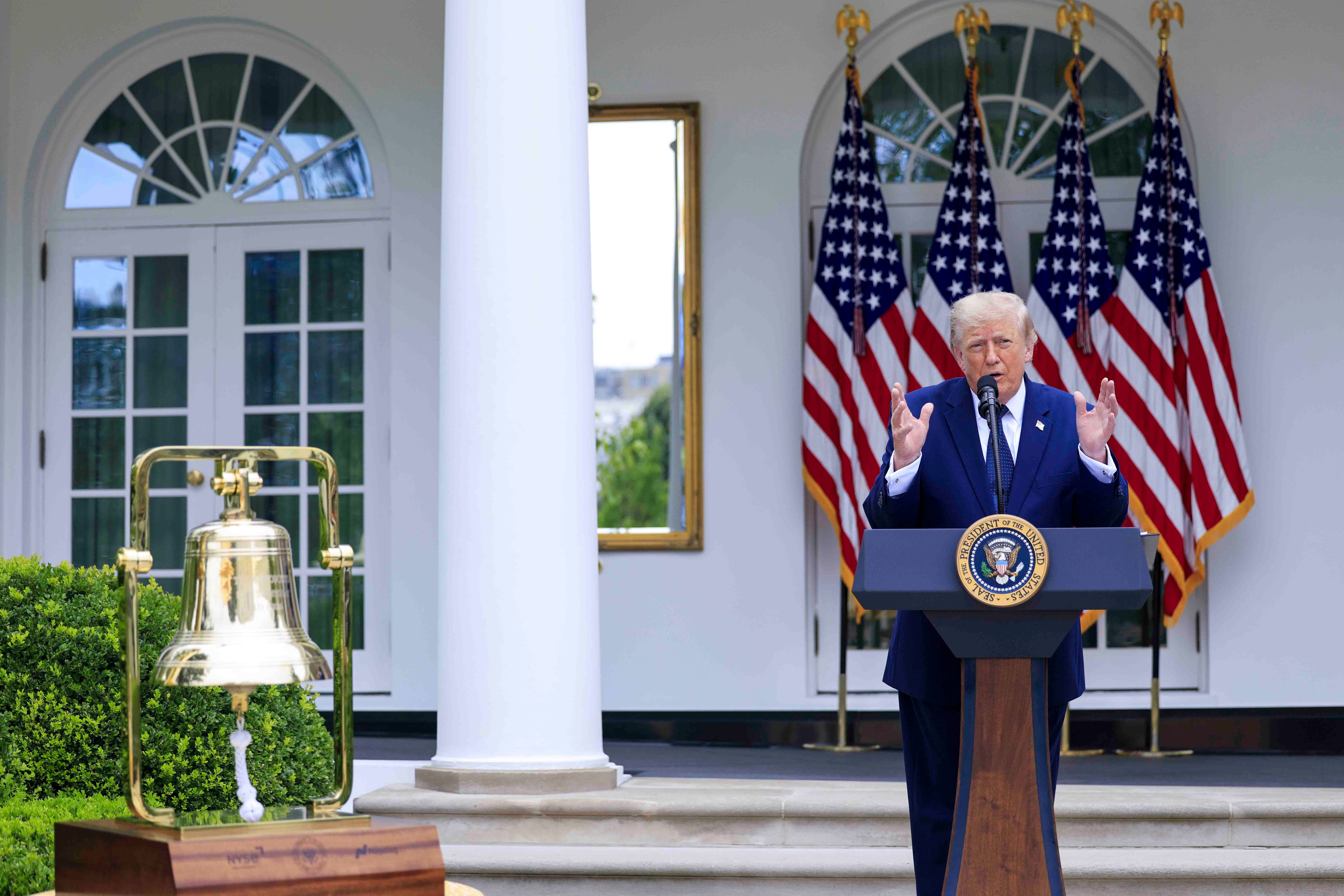 US-Präsident hält eine Rede im Rosengarten des Weißen Hauses, US-Flaggen im Hintergrund.
