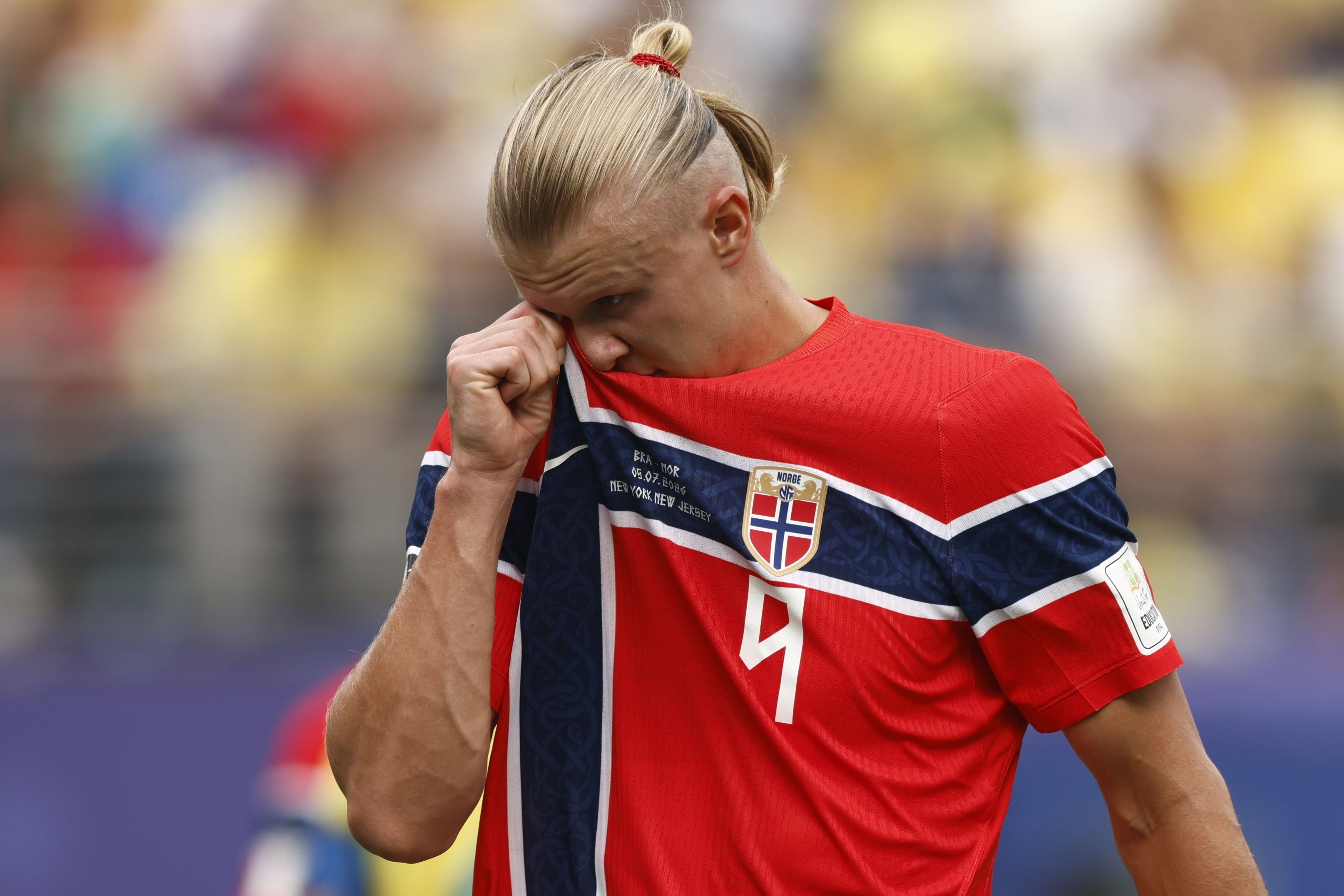 Ein norwegischer Fußballspieler wischt sich mit dem Trikot das Gesicht während eines Spiels.