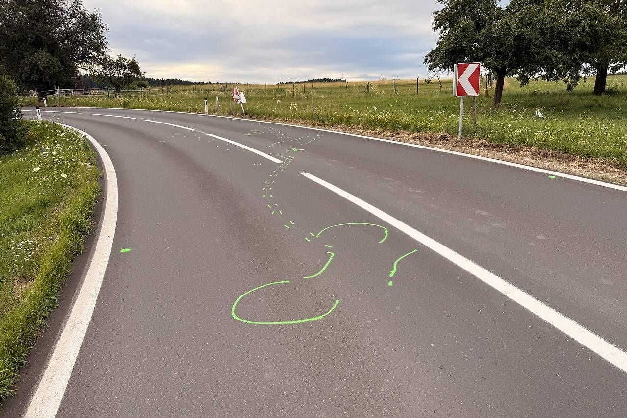 Landstraße mit grünen Markierungen auf dem Asphalt nach einem Unfall bei einer Kurve.