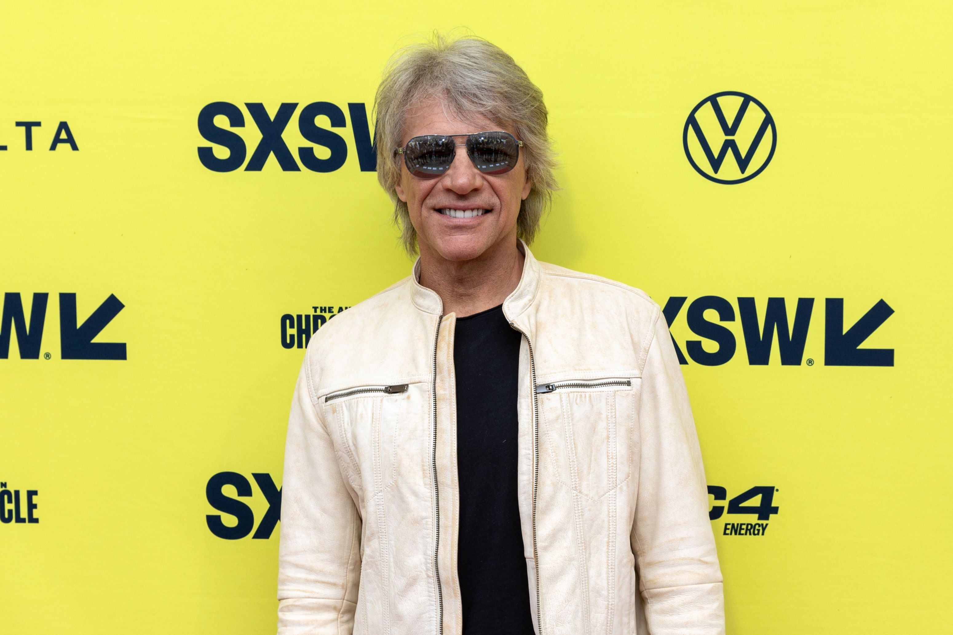 Mann mit Sonnenbrille und heller Jacke vor gelbem SXSW-Hintergrund beim Festival.