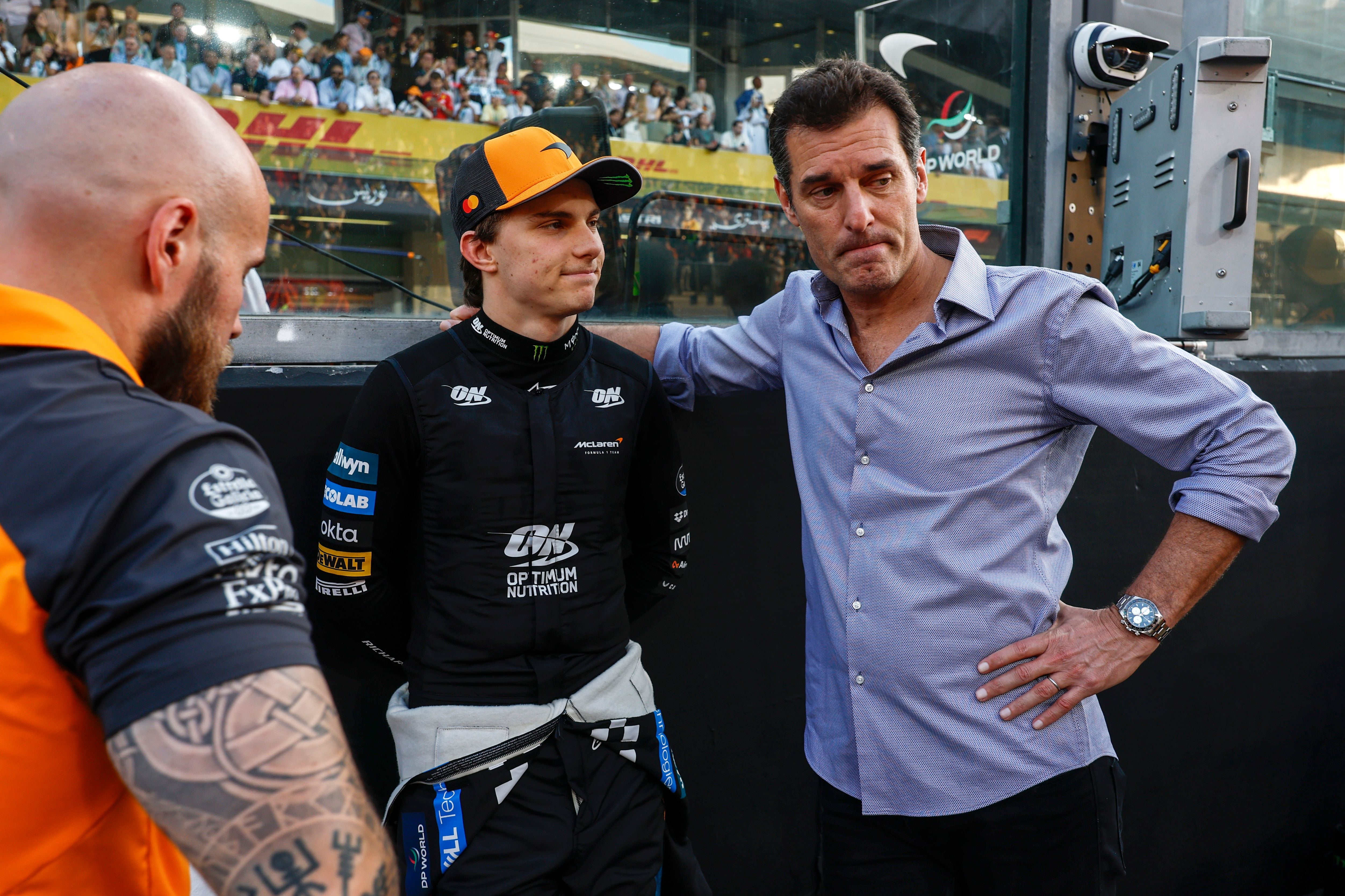 ABU DHABI, UNITED ARAB EMIRATES - DECEMBER 07: Oscar Piastri of Australia and McLaren and Mark Webber on the grid during the F1 Grand Prix of Abu Dhabi at Yas Marina Circuit on December 07, 2025 in Abu Dhabi, United Arab Emirates. (Photo by Andrew Ferraro/LAT Images)
